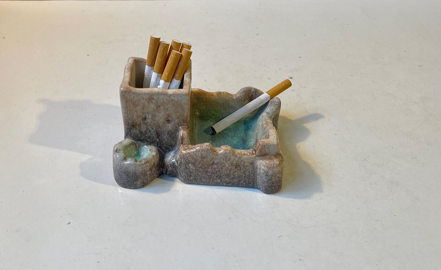 An unusual, nostalgic, political incorrect and very rare object in the shape of this smoker's station. In Denmark referred to as 'smoke Lagoon'. It dates to the mid-late 1950s and in executed in Persia Glazed pottery. Made at Michael Andersen & Son