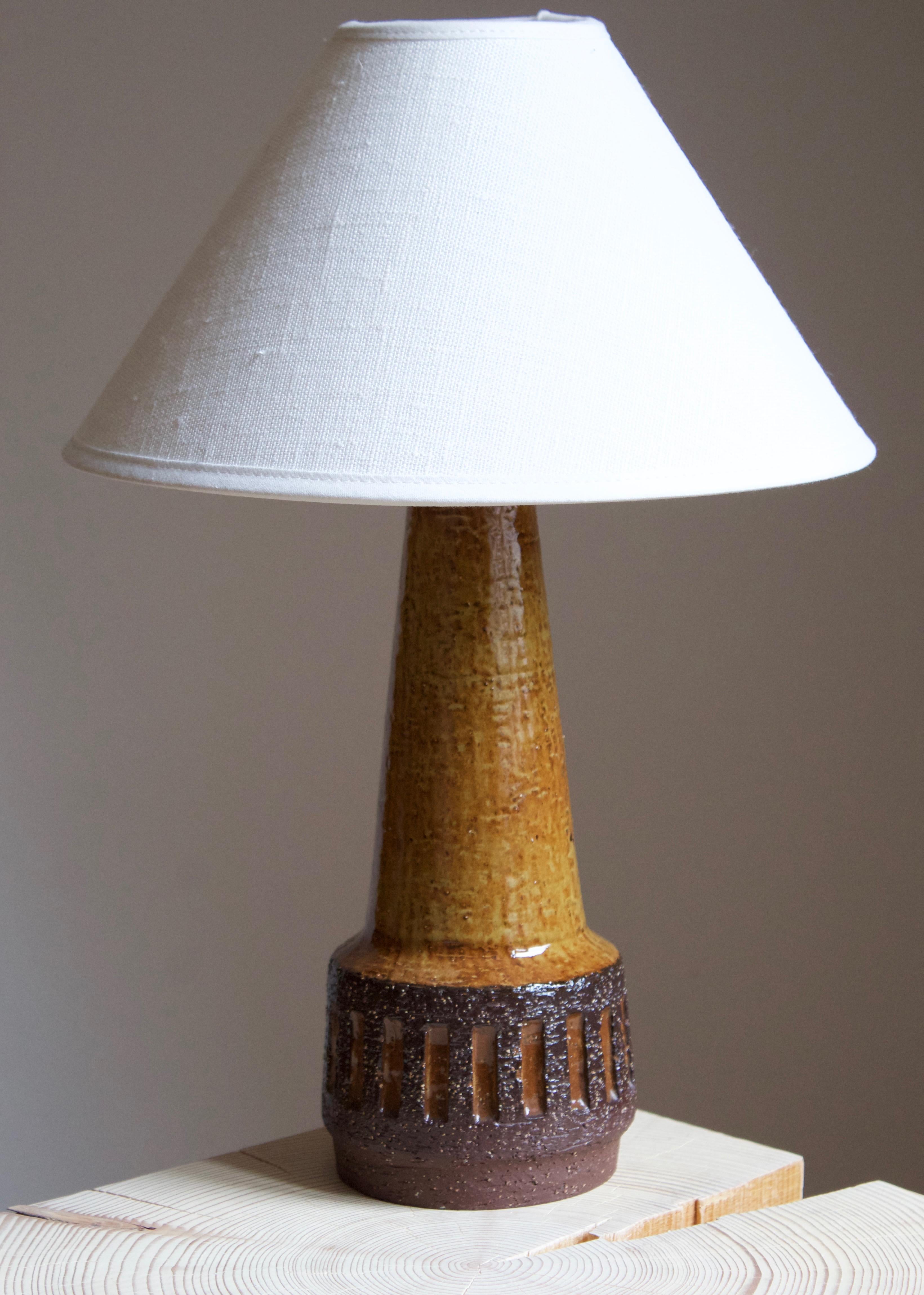 A table lamp produced by Michael Andersen Keramik. In stoneware. Marked.

Stated dimensions exclude lampshade. Height includes socket. Sold without lampshade.

Glaze features brown-green colors.

Other ceramicists of the period include Axel Salto,