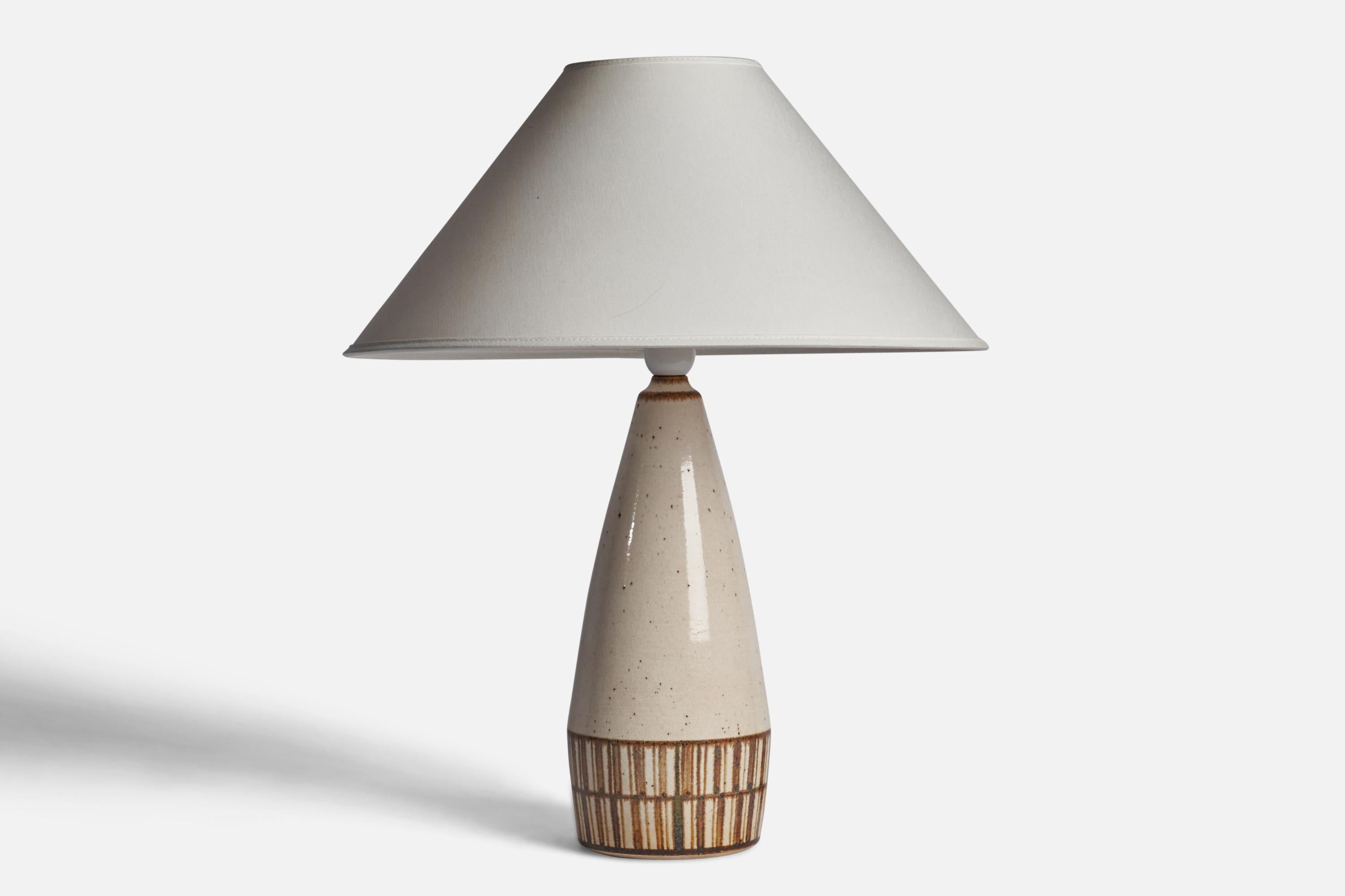 An off-white and brown-glazed stoneware table lamp designed and produced by  Michael Andersen, Bornholm, Denmark, c. 1960s.

Dimensions of Lamp (inches): 14.5 H x 5” Diameter
Dimensions of Shade (inches): 4.5” Top Diameter x 16” Bottom Diameter x