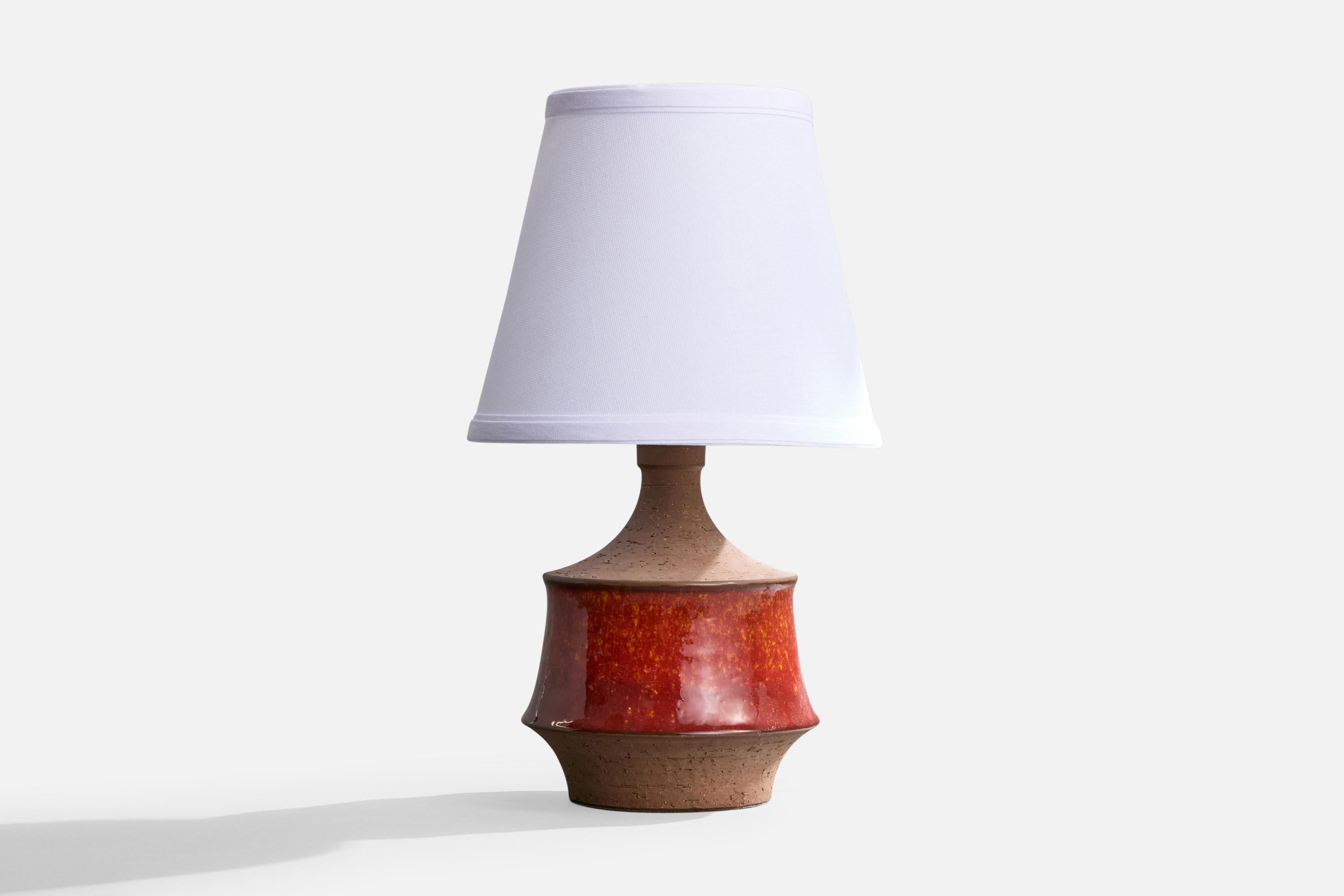 A red and brown-glazed stoneware table lamp produced by Michael Andersen, Bornholm, Denmark, c. 1960s.

Dimensions of Lamp (inches): 9.5” H x 5.875” Diameter

Dimensions of Shade (inches): 5” Top Diameter x 8” Bottom Diameter x 7” H

Dimensions of