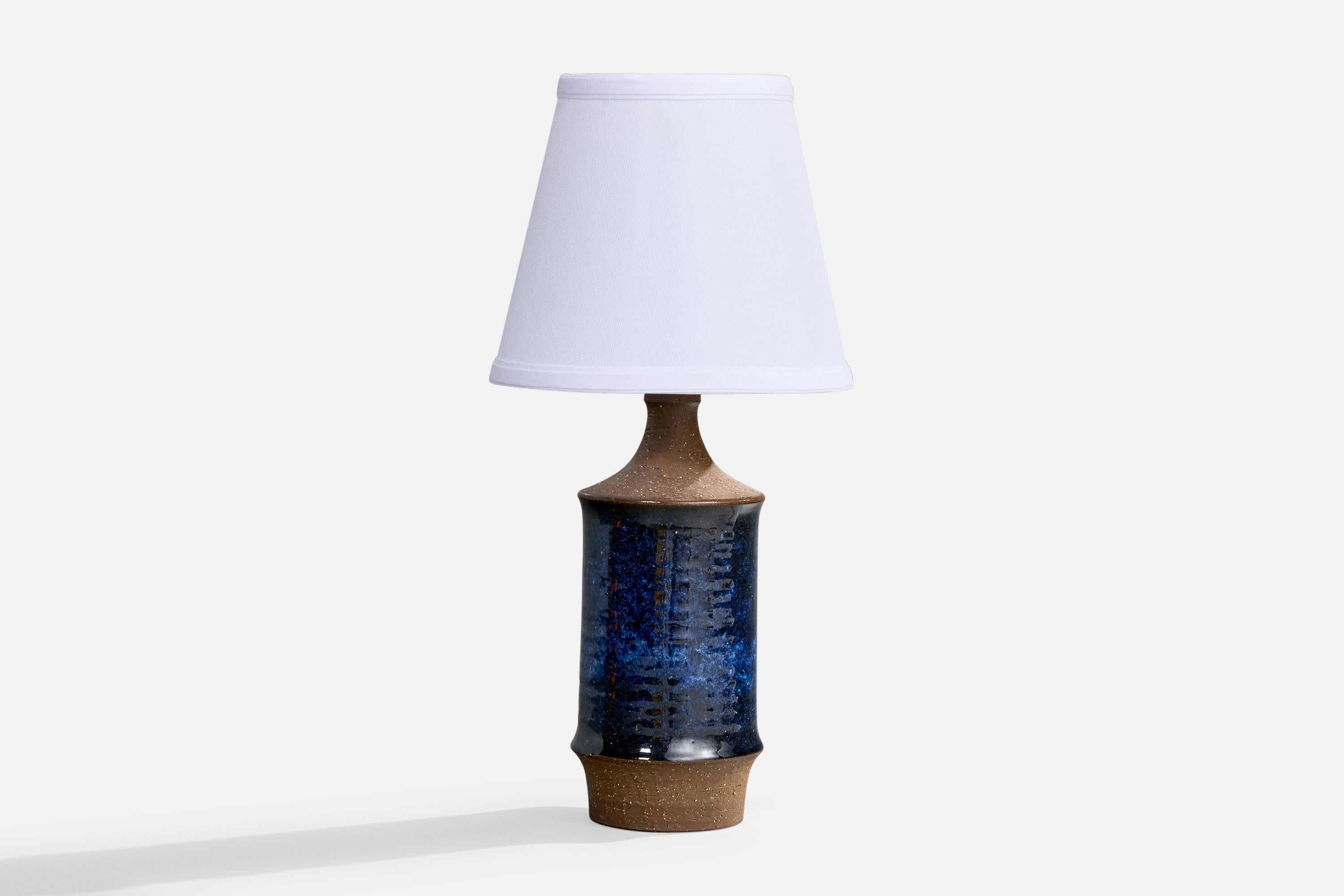 A blue and brown-glazed stoneware table lamp produced by Michael Andersen, Bornholm, Denmark, c. 1960s.

Dimensions of Lamp (inches): 12“ H x 4.25“ Diameter

Dimensions of Shade (inches): 5” Top Diameter x 8” Bottom Diameter x 7“ H

Dimensions of
