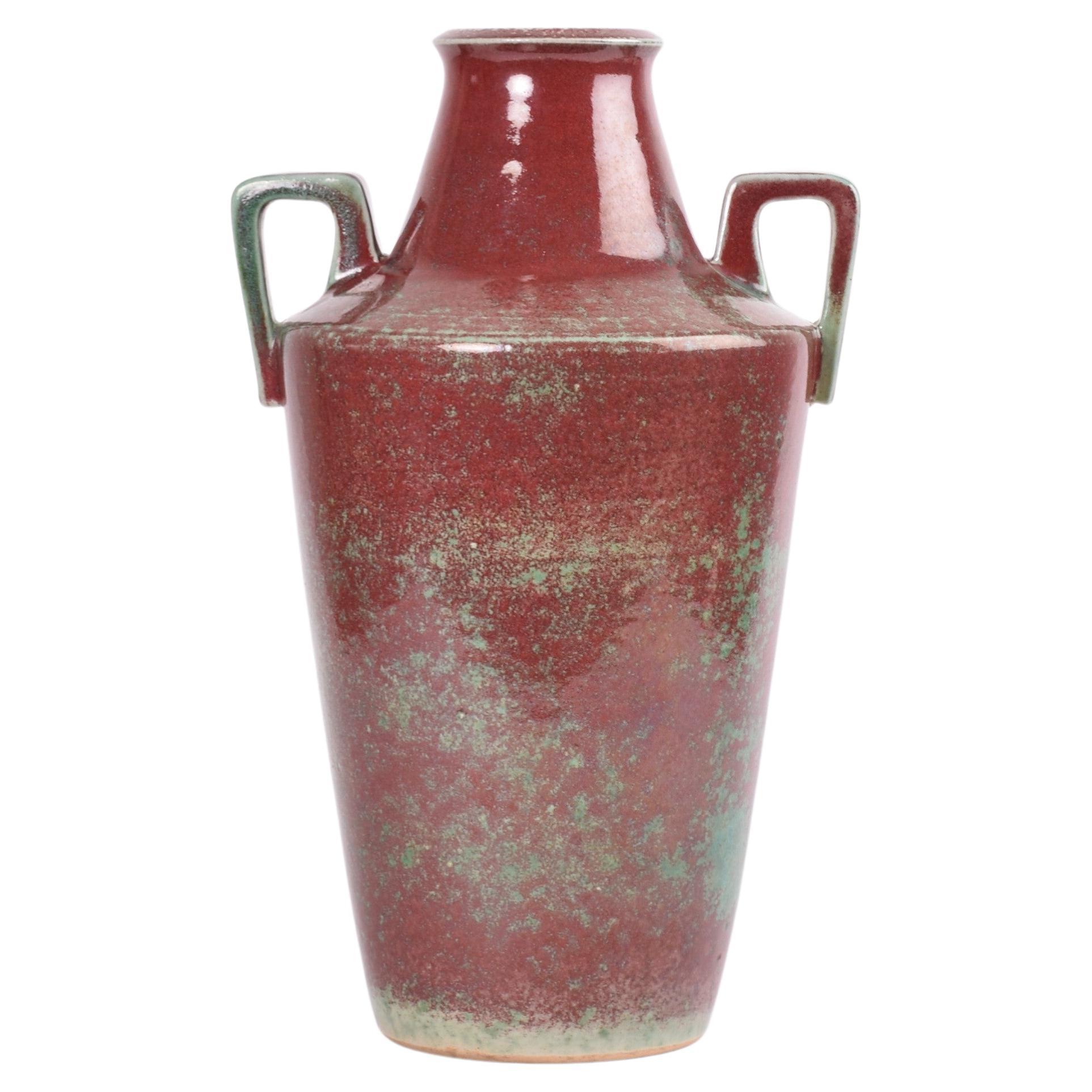 Unique Danish Art Deco handled vase from the acknowledged ceramic manufacturer Michael Andersen & Søn. Made ca 1920s to 30s.
The vase is covered with a oxblood red glaze with emerald green.

The vase is handsigned on bottom which indicates that