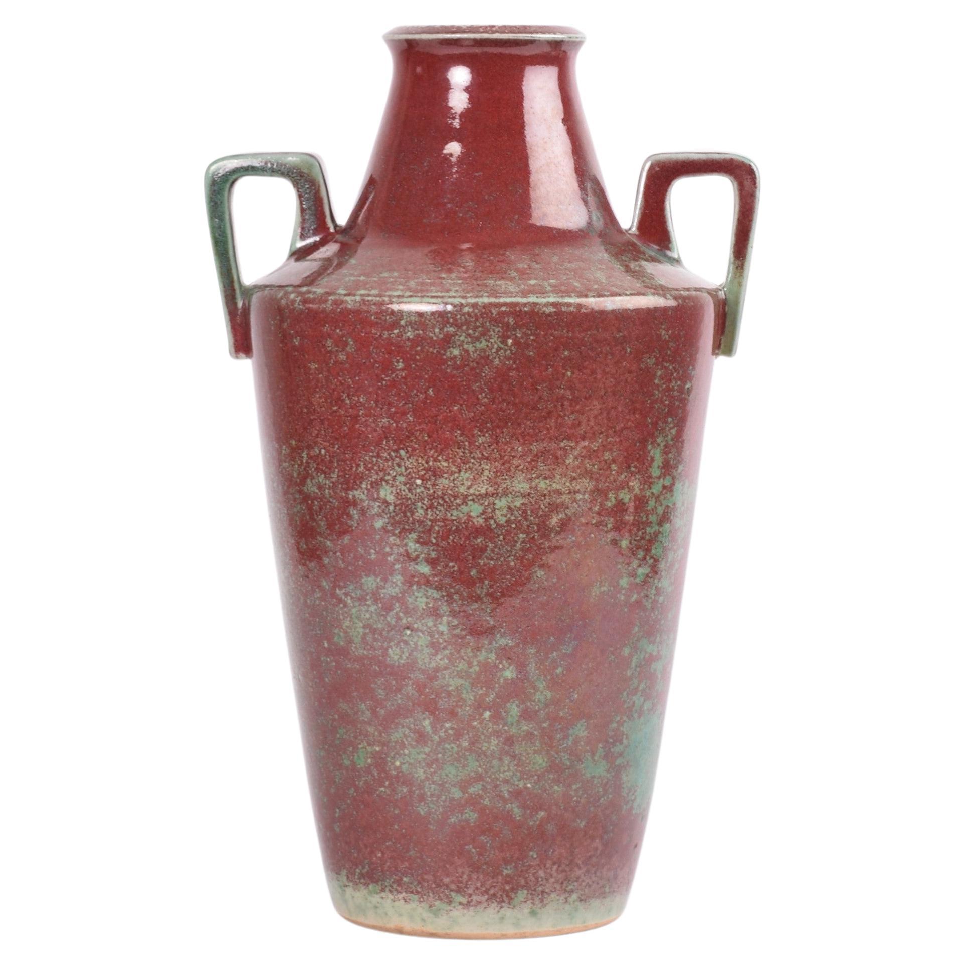 Unico vaso danese con manico in stile Art Déco del rinomato produttore di ceramiche Michael Andersen & Søn. Realizzato tra gli anni '20 e '30 circa.
Il vaso è ricoperto da uno smalto rosso sangue di bue e verde smeraldo.

Il vaso è firmato sul