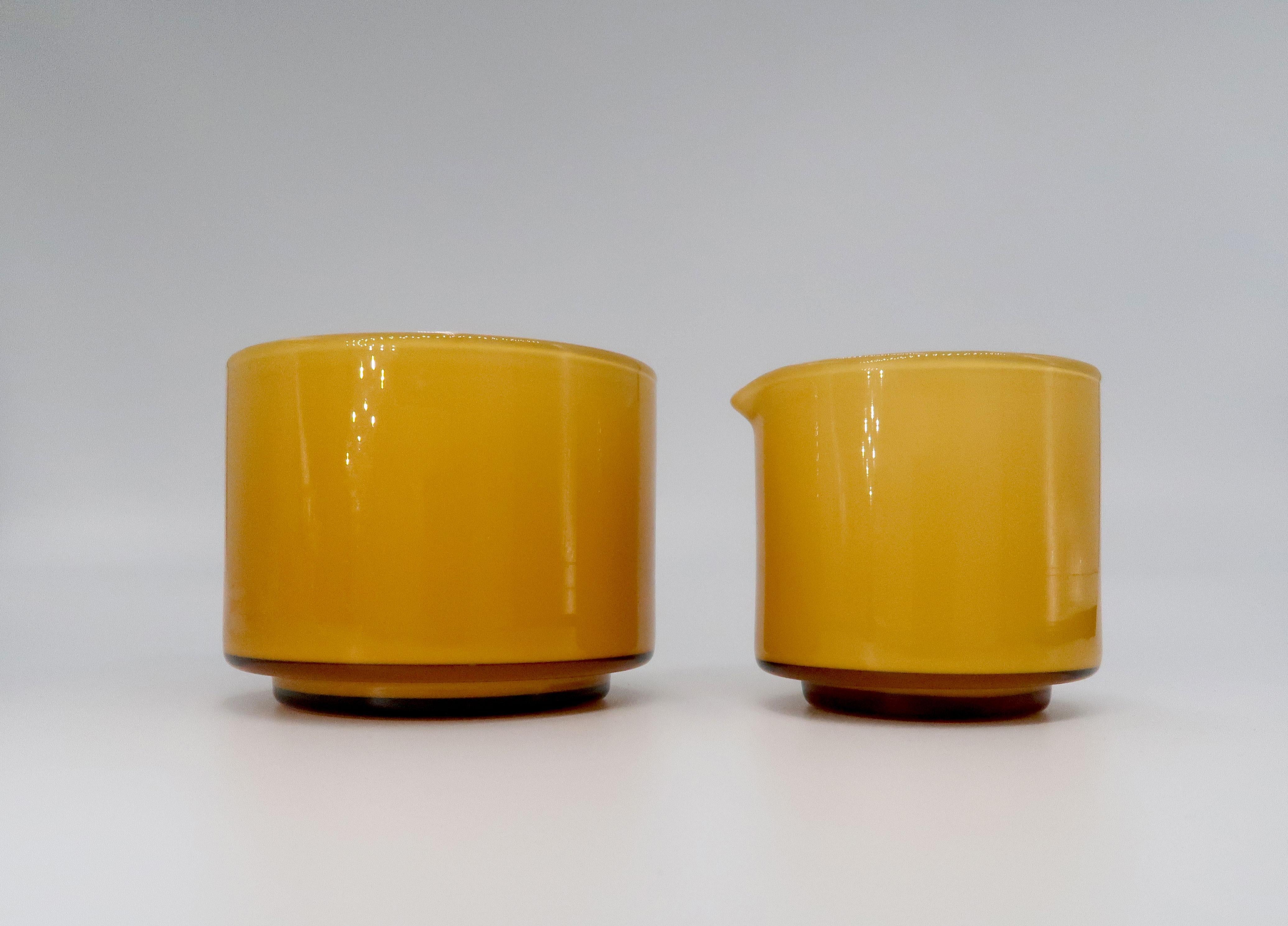 Beautiful Danish modern umber, warm caramel and milky white glass sugar bowl and creamer set. Designed by Michael Bang for Danish Holmegaard Glassworks manufactured in 1970. From the Palet series. 
Both in excellent condition.
Denmark, 1970. 