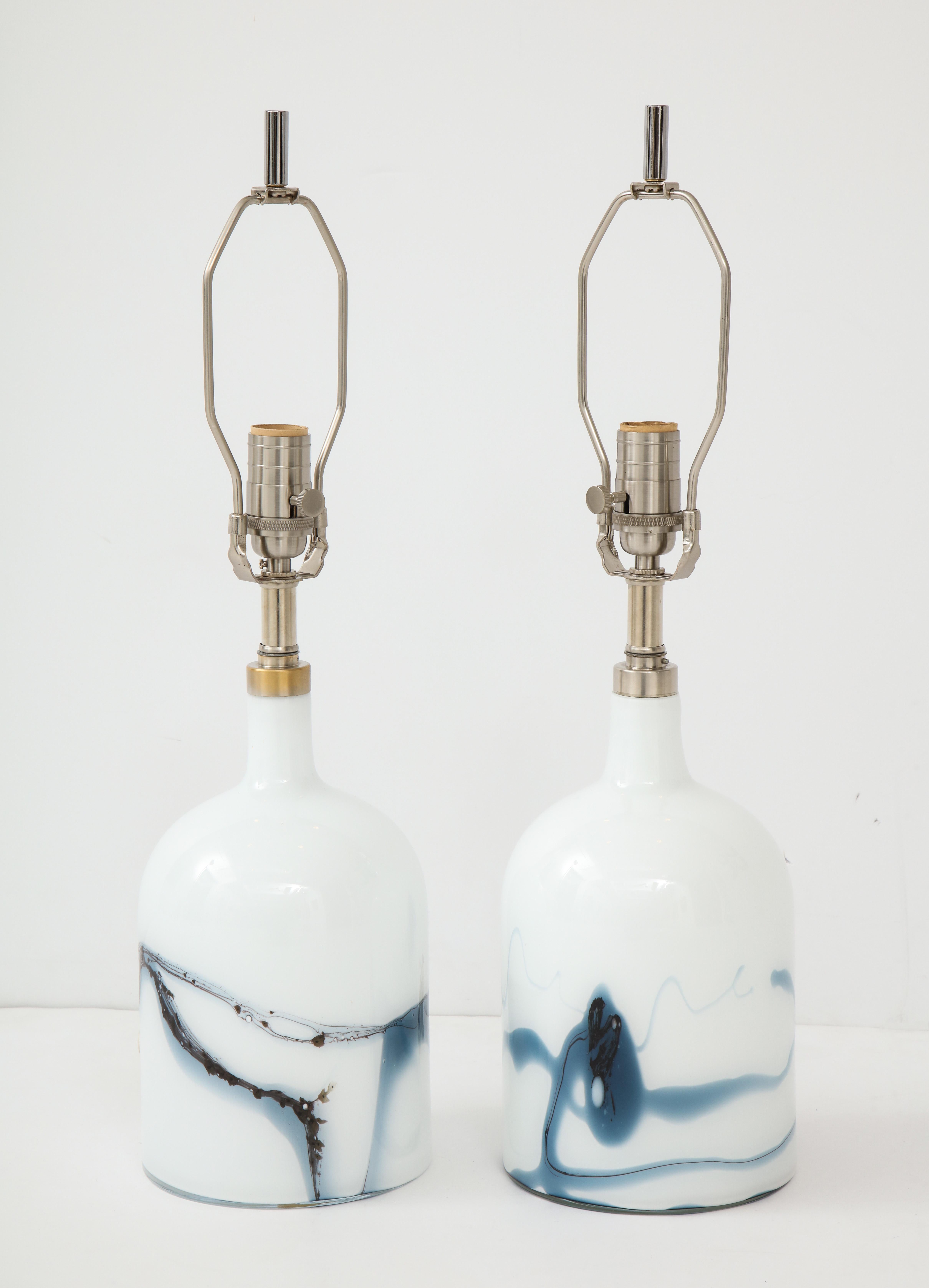 Pair of Swedish modern white bottle form glass lamps with medium smokey blue glass inclusions. Rewired for use in the USA. Michael Bang for Holmegaard.