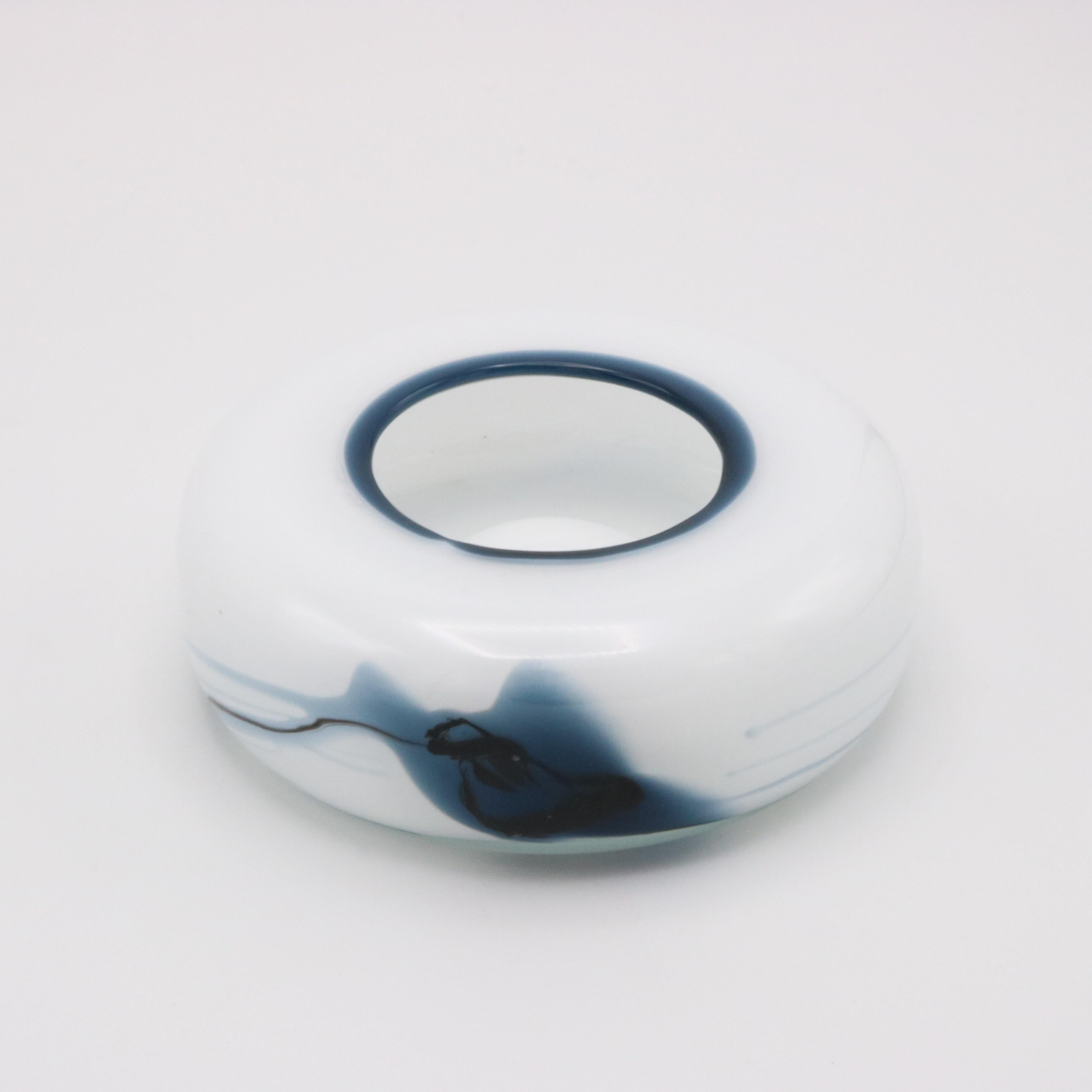 A Danish Holmegaard  glass bowl vase designed by Michael Bang from Denmark circa 1970. The opaque white glass with blue colored swirl patterns.