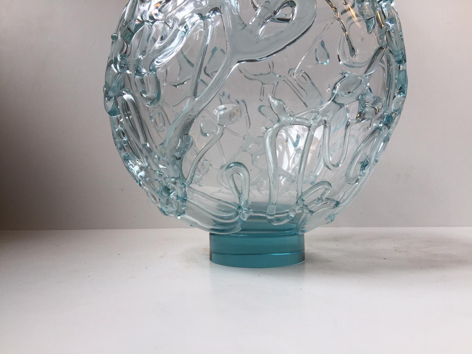 Grande vaso circolare in vetro artistico trasparente di colore azzurro. È un pezzo unico ed è firmato dall'artista, numerato e datato. È decorato con fili di vetro applicati che creano un motivo astratto lungo tutto il perimetro del vaso. Alcuni di