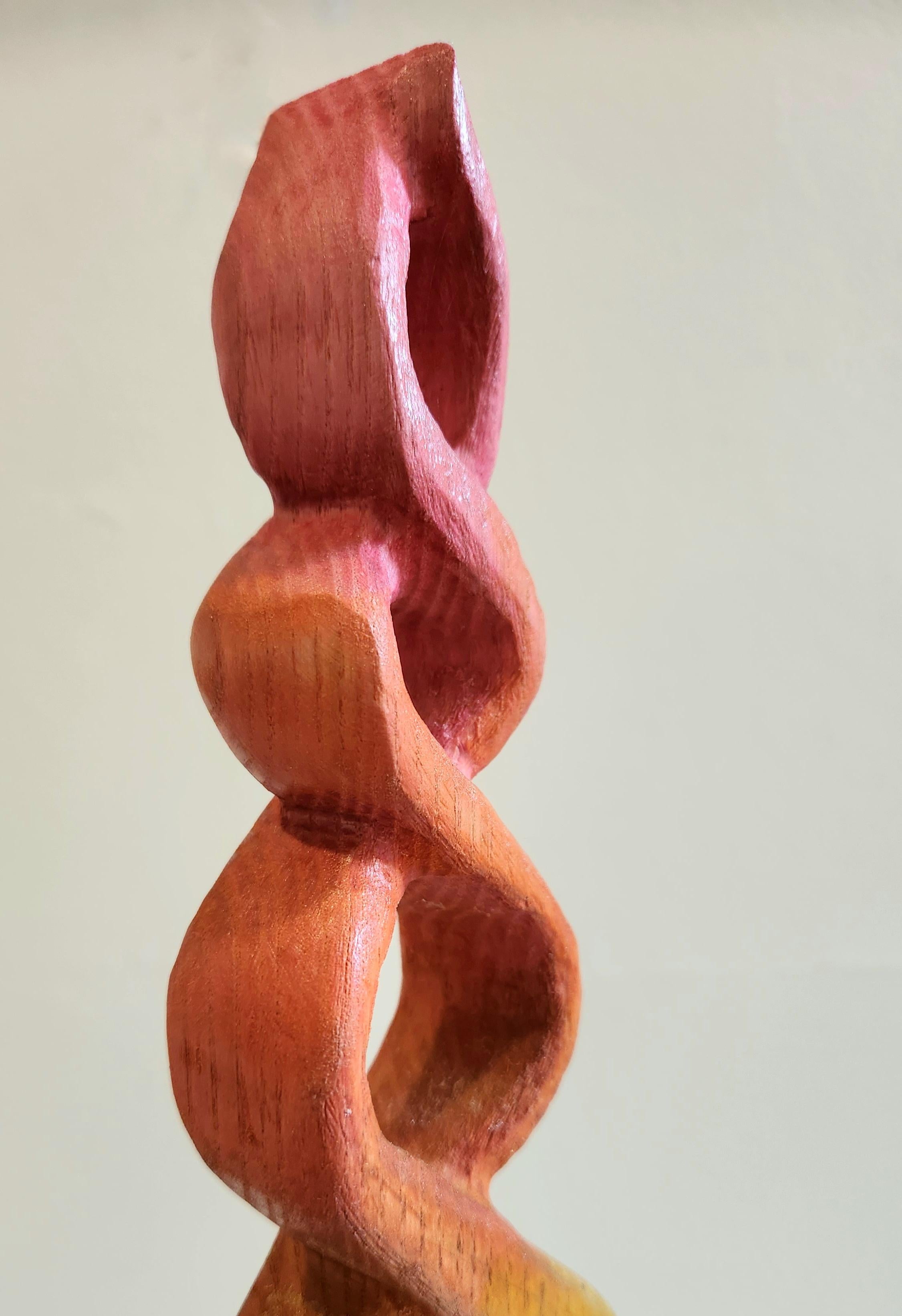 Questa scultura astratta in legno è realizzata in Oak Oak. Esso  consiste in un grazioso oggetto alto di braccia intrecciate con colori cangianti dal basso verso l'alto. I colori includono il verde limone, il giallo e il rosa eseguiti in tonalità