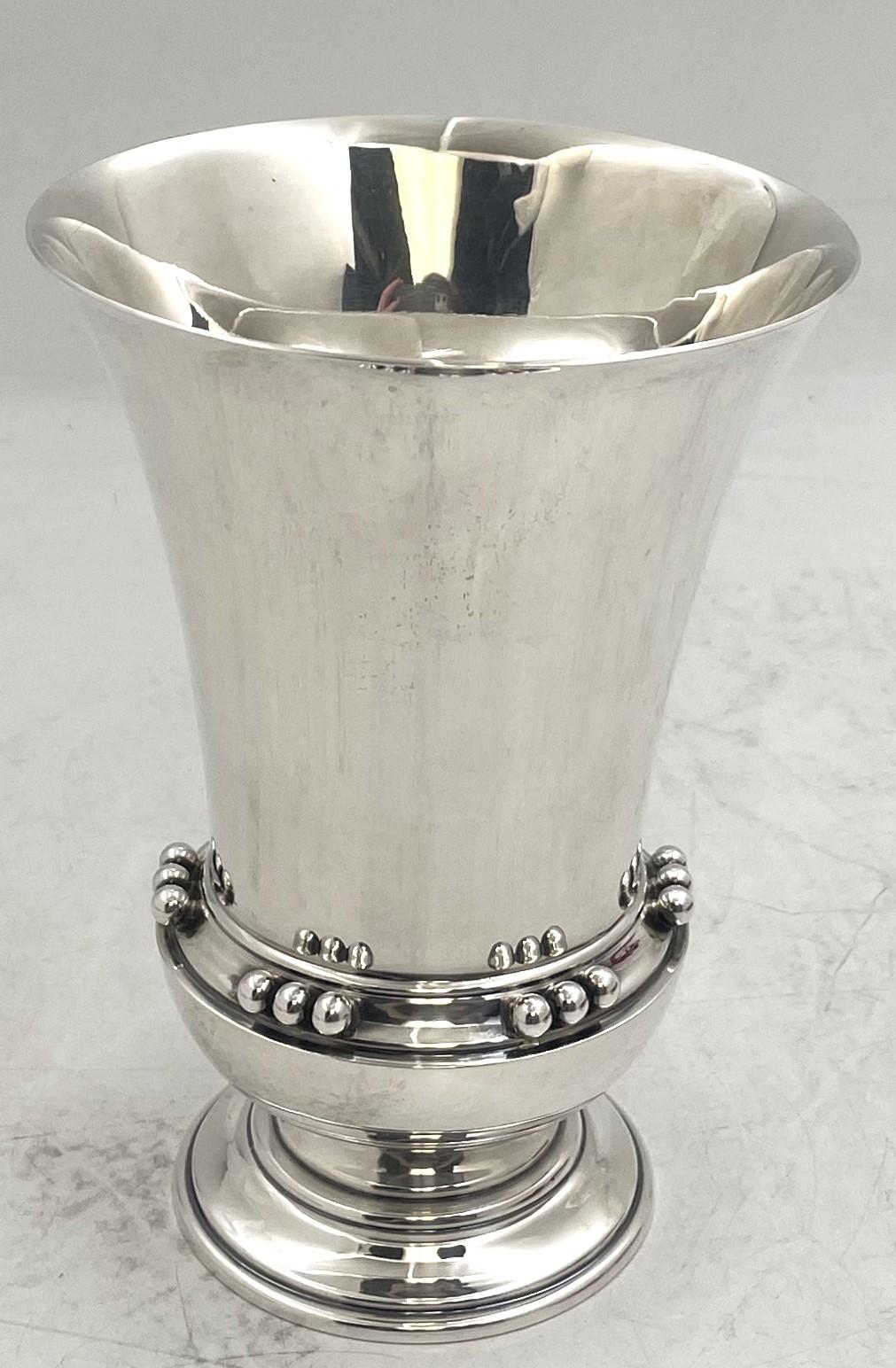 Michael C. Fina sterling silver vase in Mid-Century Modern style in an elegant, geometric design. It measures 6 1/2'' in height by 4 3/4'' in diameter at the top, weighs 10.4 troy ounces, and bears hallmarks as shown.

Founded by Michael Charles
