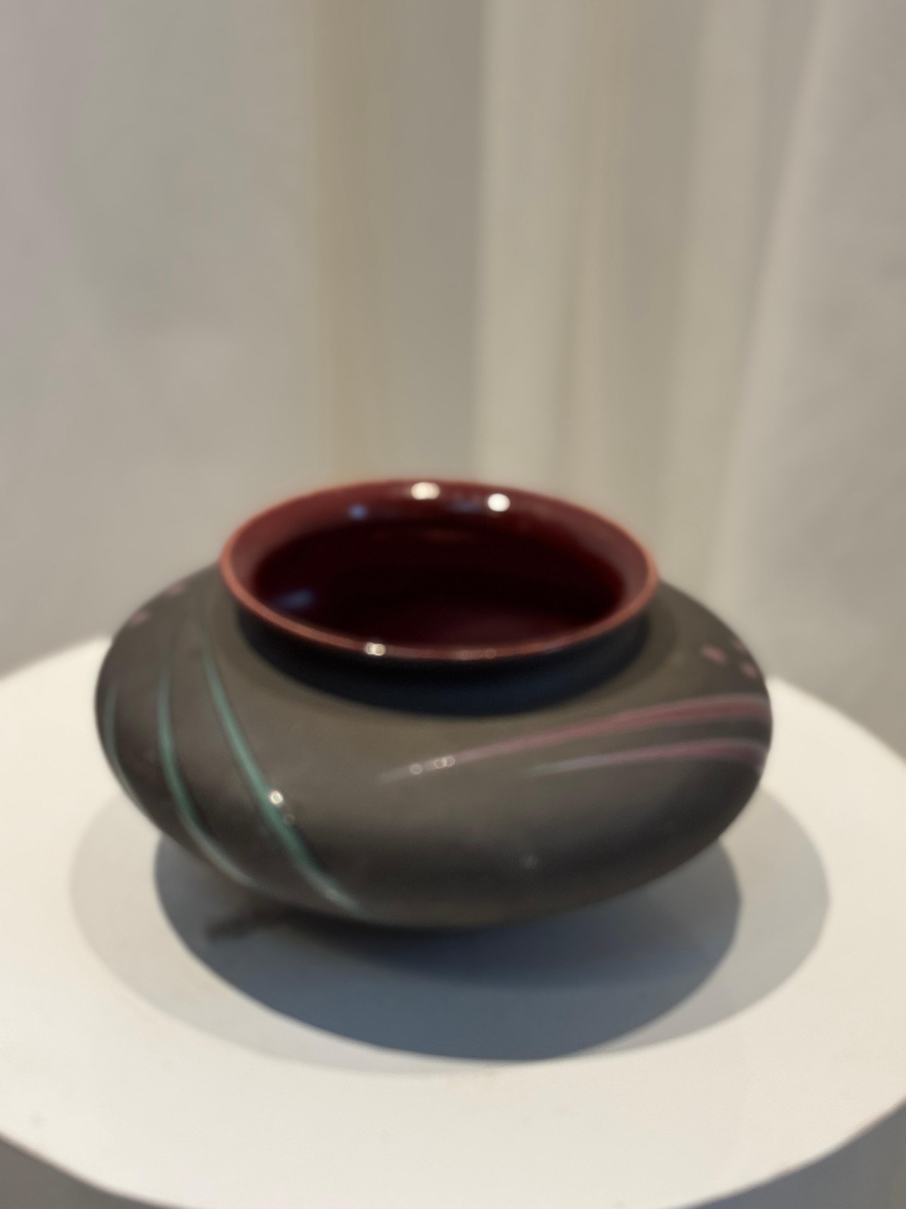 Diese atemberaubende Studio Art Pottery Vase von Michael Cho ist ein meisterhaft handgefertigtes Keramikstück, das eine elegante Mischung aus strukturierten matten und glänzenden glasierten Oberflächen aufweist. Das Äußere ist mit zarten,