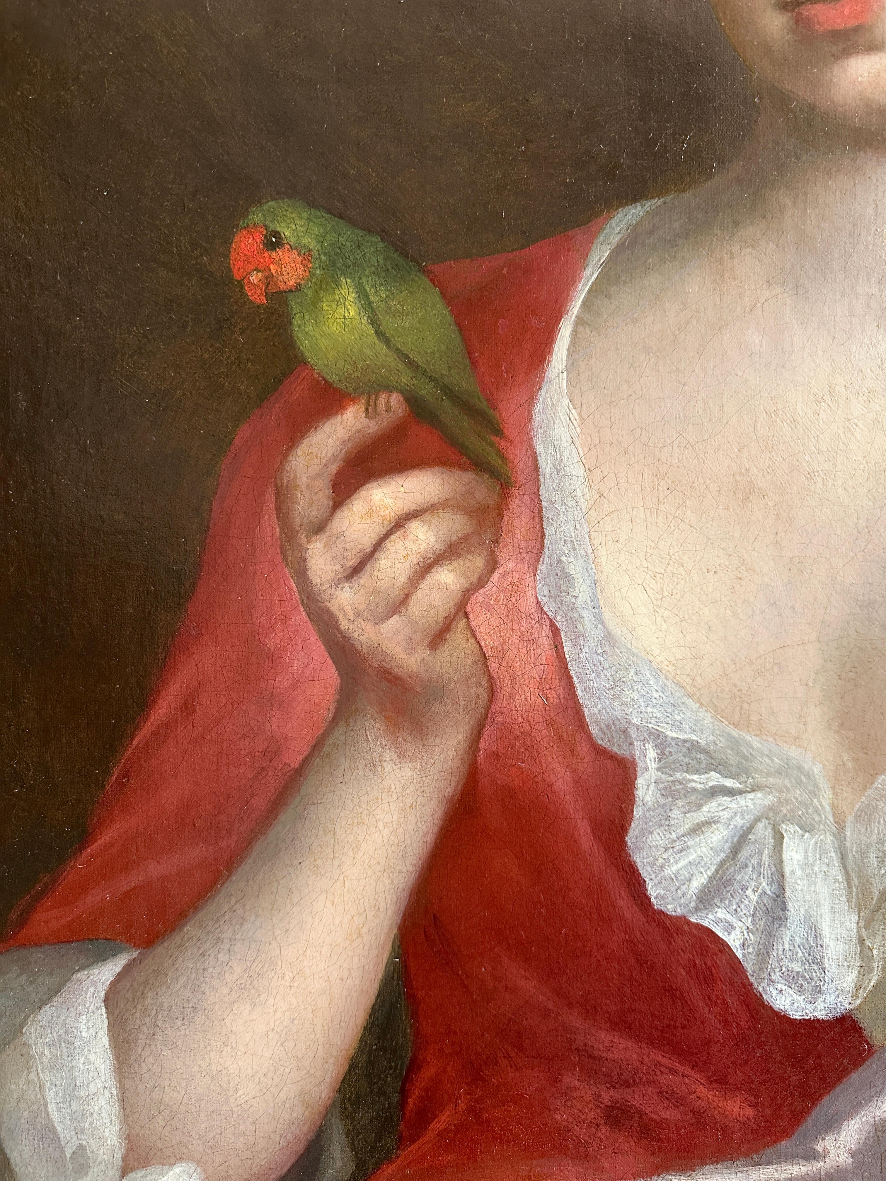 A portrait of a lady three-quarter length, seated in an interior, wearing a red silk gown draped in a pink silk sash with an exotic bird perched on her hand and one arm resting on a stone plinth,  her young daughter wearing a green silk gown