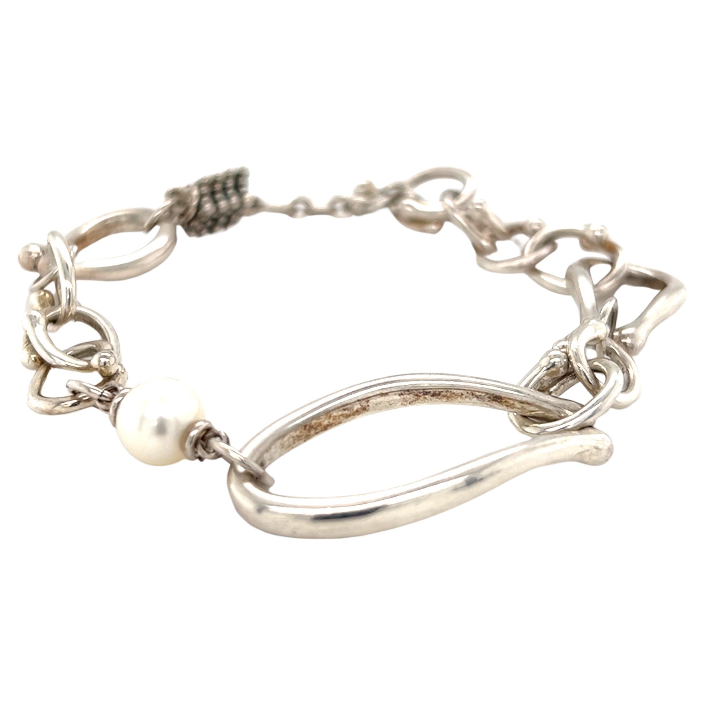 One sterling silver (stamped Michael Dawkins 925) multi-link bracelet set with one 7.9mm freshwater pearl.  The bracelet measures 8.5 inches long, weighs 23.9 grams, and is complete with a toggle closure.  