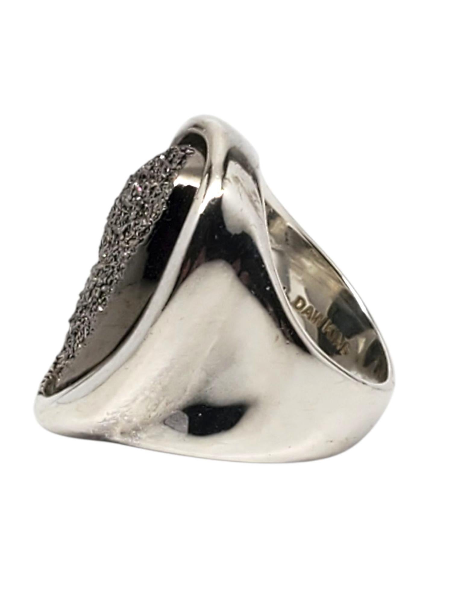 Michael Dawkins - Anello a cupola in argento granulato

Questo audace anello a cupola di Michael Dawkins presenta la sua caratteristica texture granulata in un design ovale in rilievo con linee scultoree e lati lucidi realizzati in argento