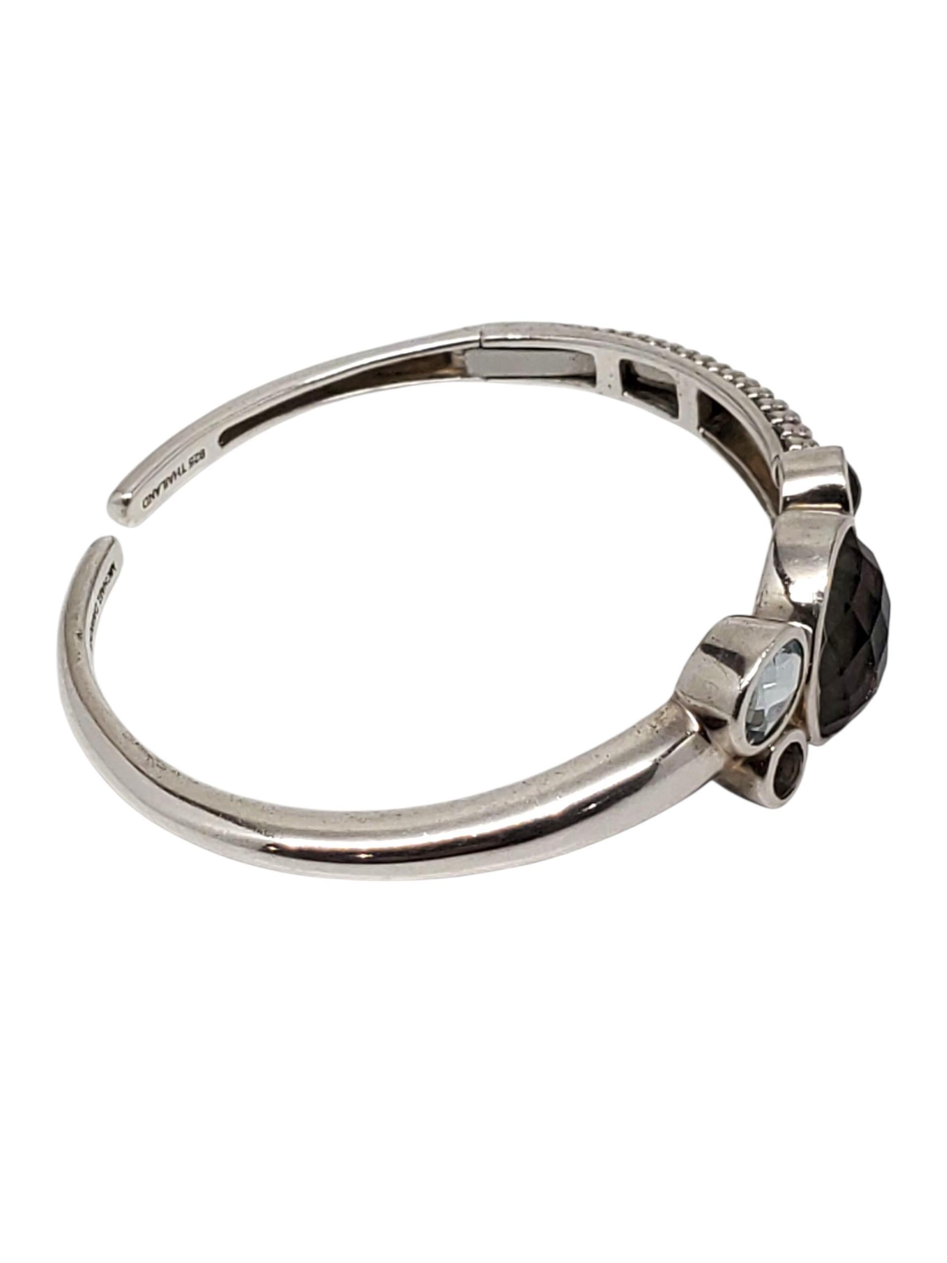 Michael Dawkins - Bracciale con cerniera in argento 925 -

Questo bellissimo bracciale con cerniera di Michael Dawkins è caratterizzato da pietre incastonate in tonalità blu e fumé neutre, incastonate in argento sterling con accenti