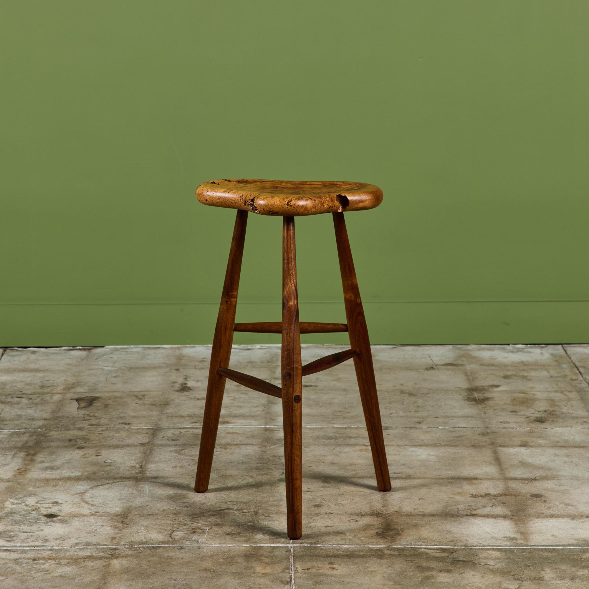 Studio craft stool designed by mostly self taught designer, Michael Elkan, c.1970's USA. This stool features a gorgeous maple burl seat. The stool is supported by three tapered legs with stretchers in varying heights. Signed on the underside.

In