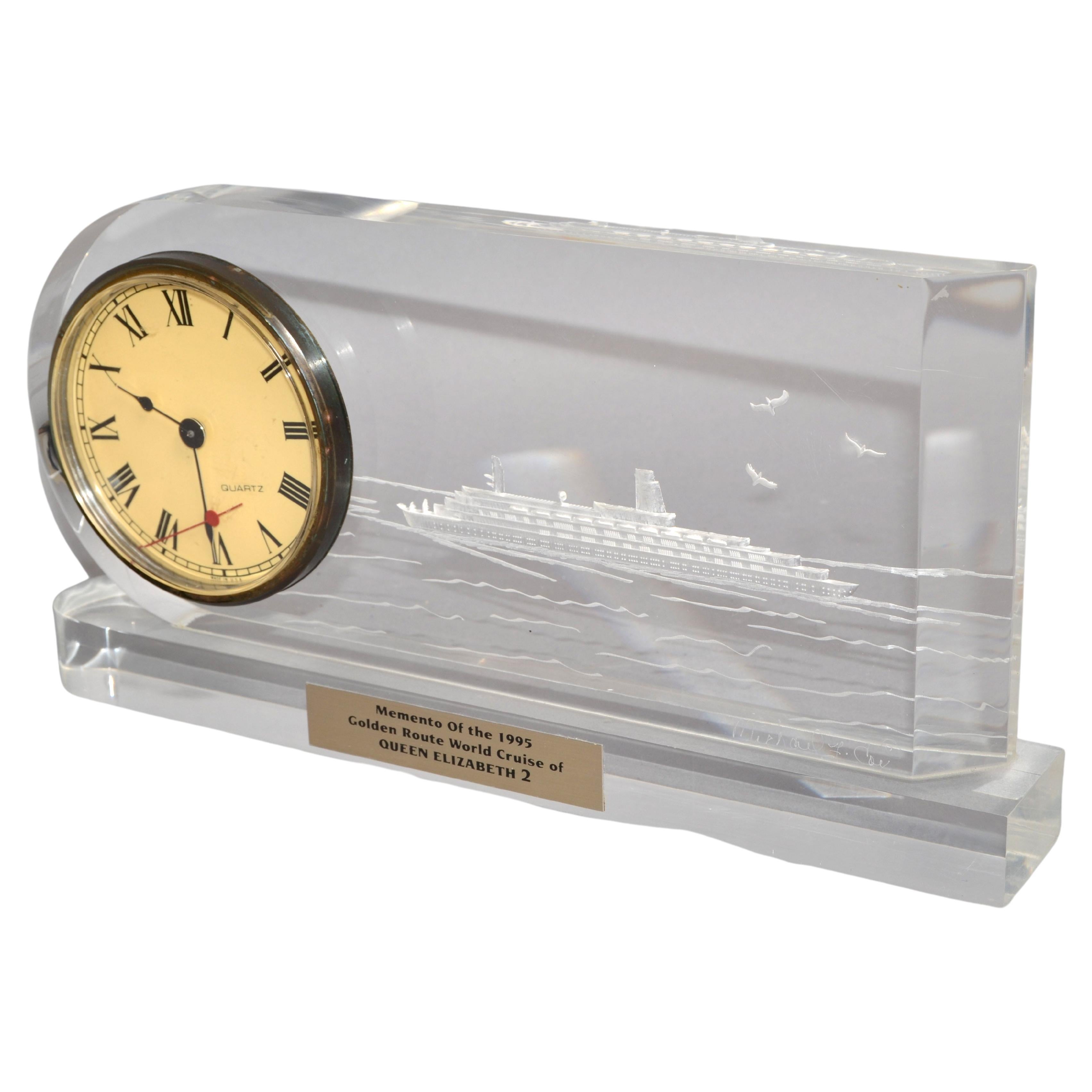 Late 20th century Solid Lucite Desk Clock Reversed Etched Nautical Picture of the Queen Elizabeth 2 at See.
Signed by the Artist Michael F. Cox at the right corner.
Insert in the Lucite is a Quartz Clock which takes a 1.5 V LR1 Battery.
Plaque on