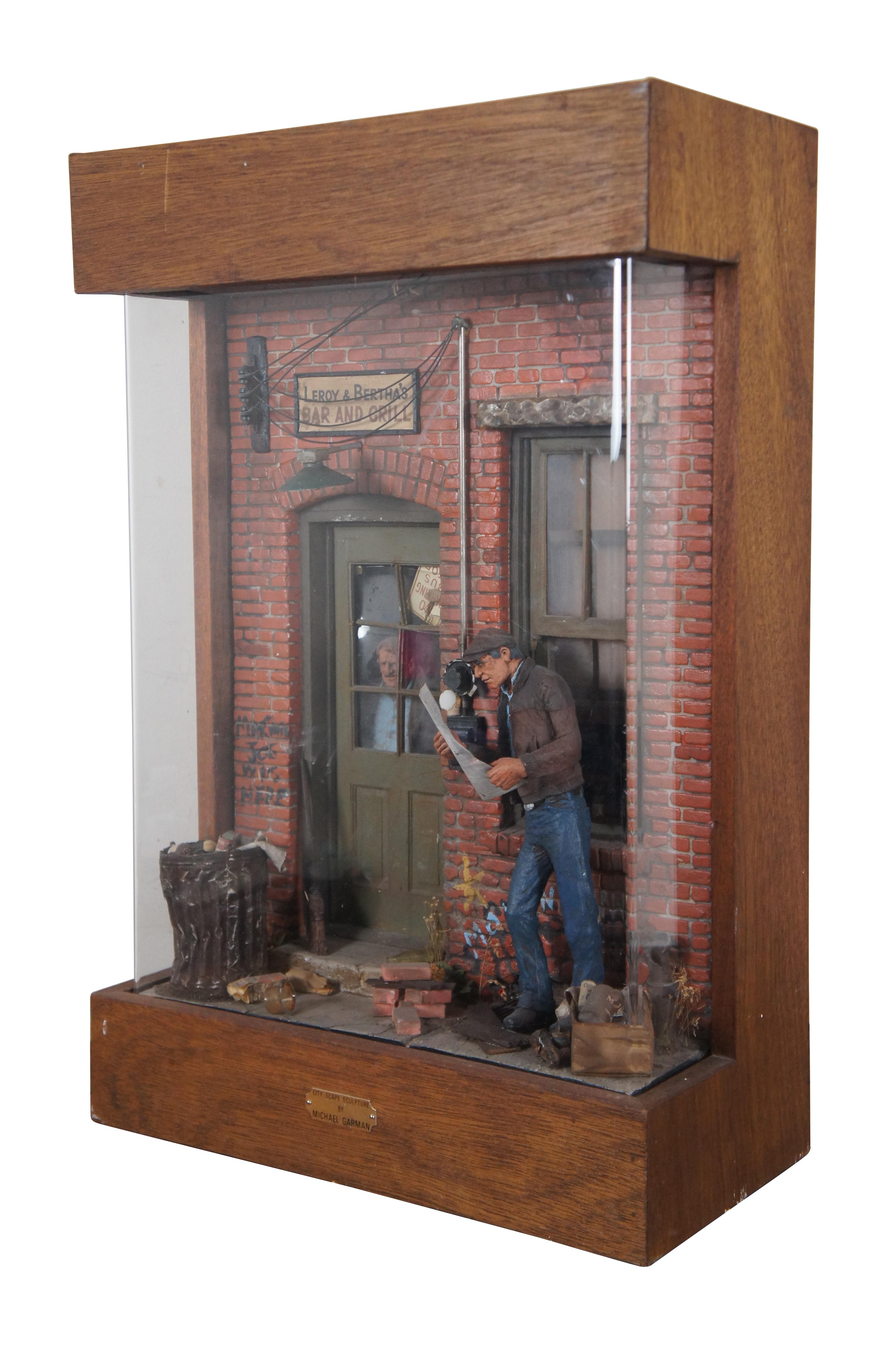 Vintage 1970’s diorama / shadowbox sculpture titled Yesterday’s News by Michael Garmin. This tableau is a recreation of a part of Garmin’s extensive Magic Town and shows a man leaning against and alley wall reading a newspaper. A sign above the