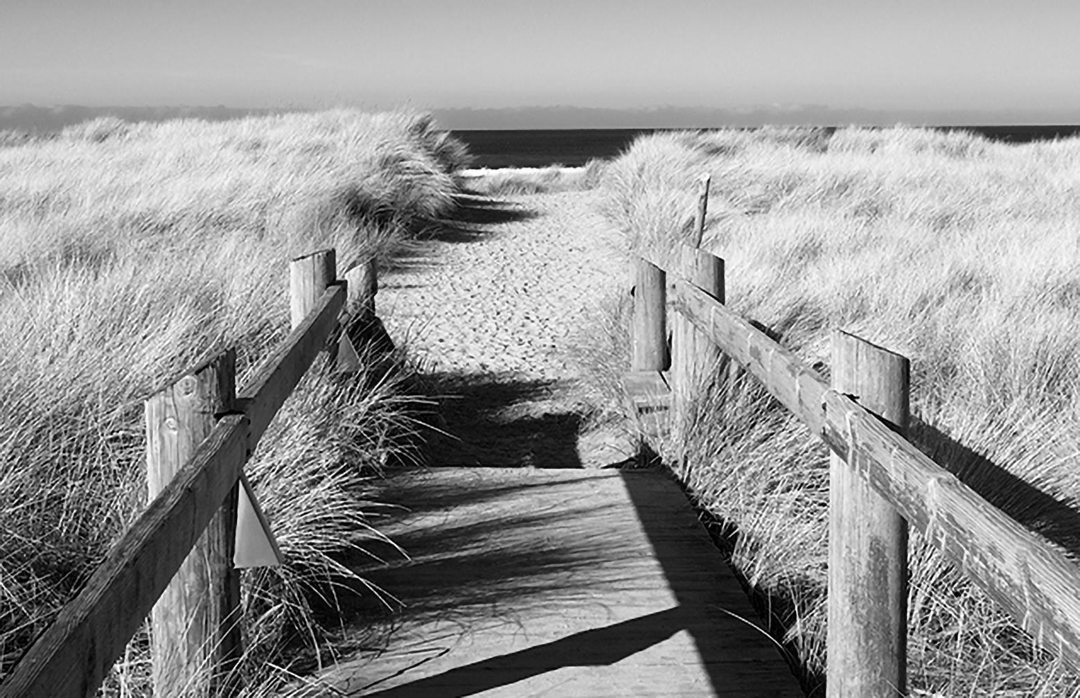 Crossing - contemporary black/white landscape photography with dock to ocean  - Photograph by Michael Götze