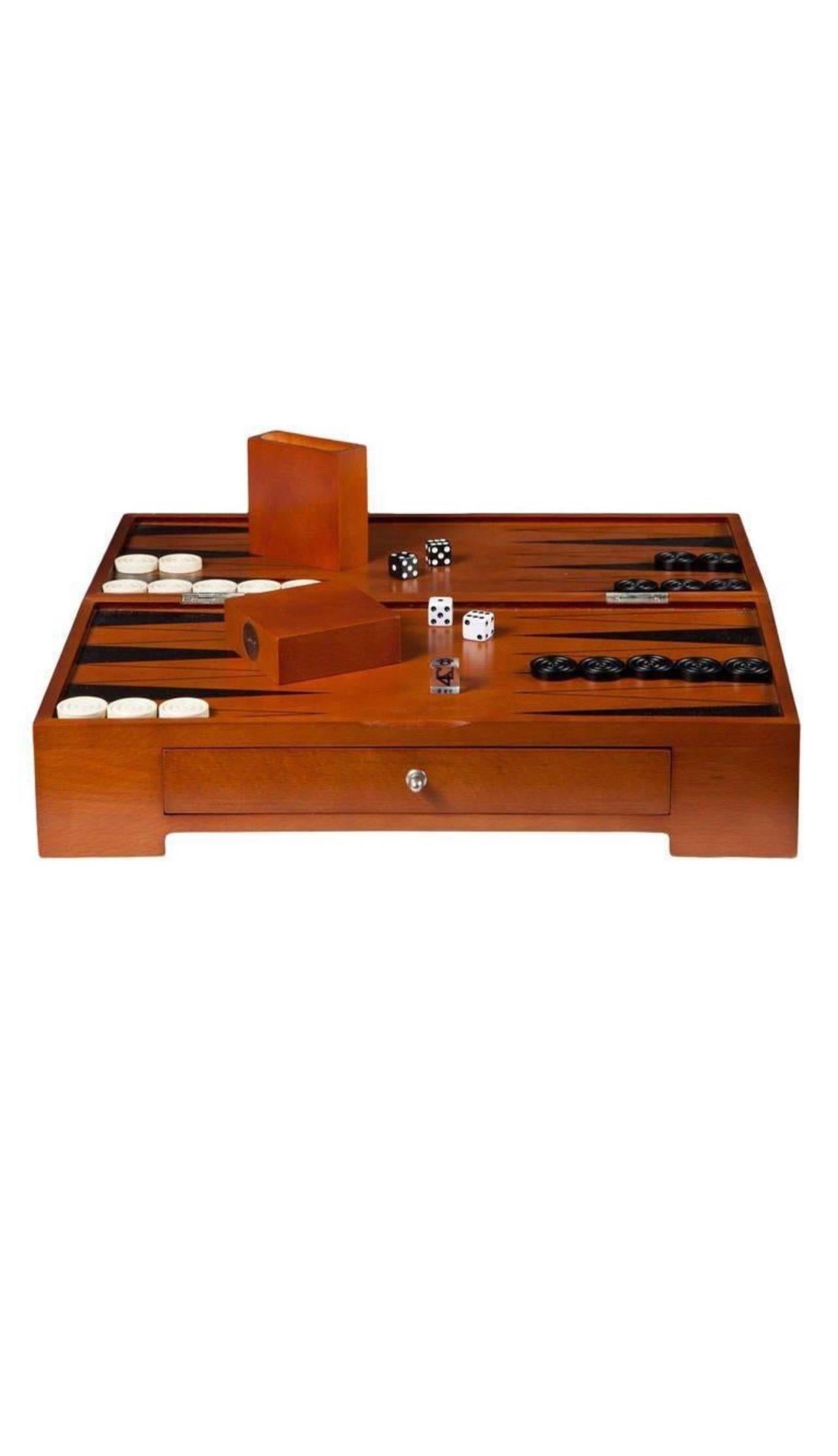 A backgammon board designed by famed architect Michael Graves. 

Imported, circa 1990. 

Signed with metal tag.

Finely constructed of cherry stained hardwood and veneers. 
Features legs that fold out to support board and a felt-lined drawer for