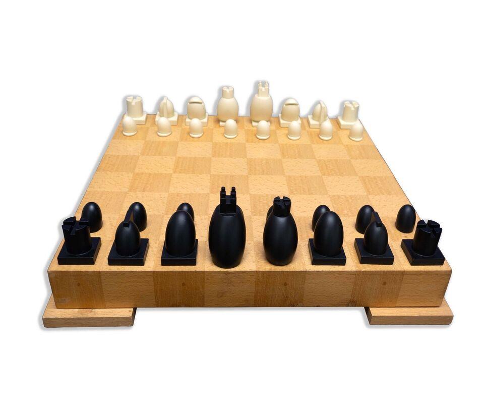 This contemporary modern chess and checkers set, designed by Michael Graves, features a beautifully crafted wooden board that showcases the natural grain of the wood. The chess pieces are elegantly simplistic, with a two-tone color scheme that