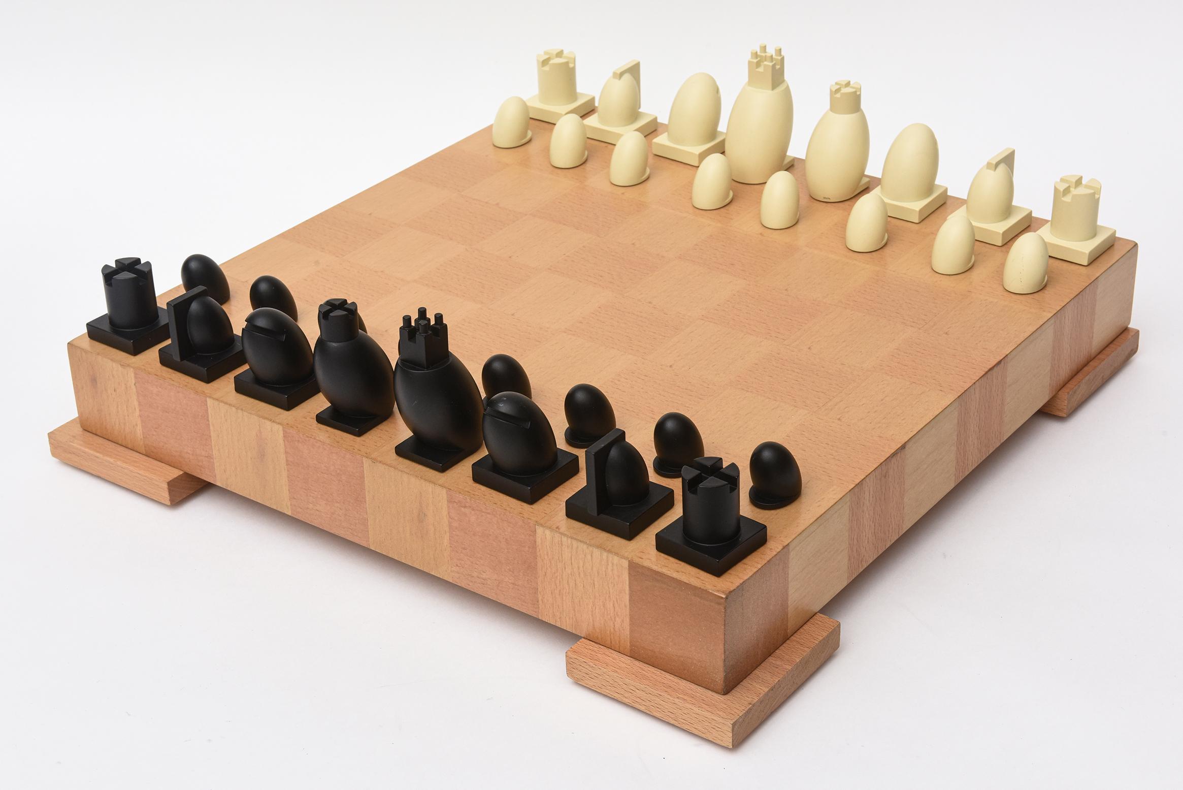 This original Postmodern Michael Graves chess set with checkers pieces has been fully restored with the wood which is 2 variants of maple. 
The wood was redone and new felt was put on the bottom. The resin players are a composition. It has velvet