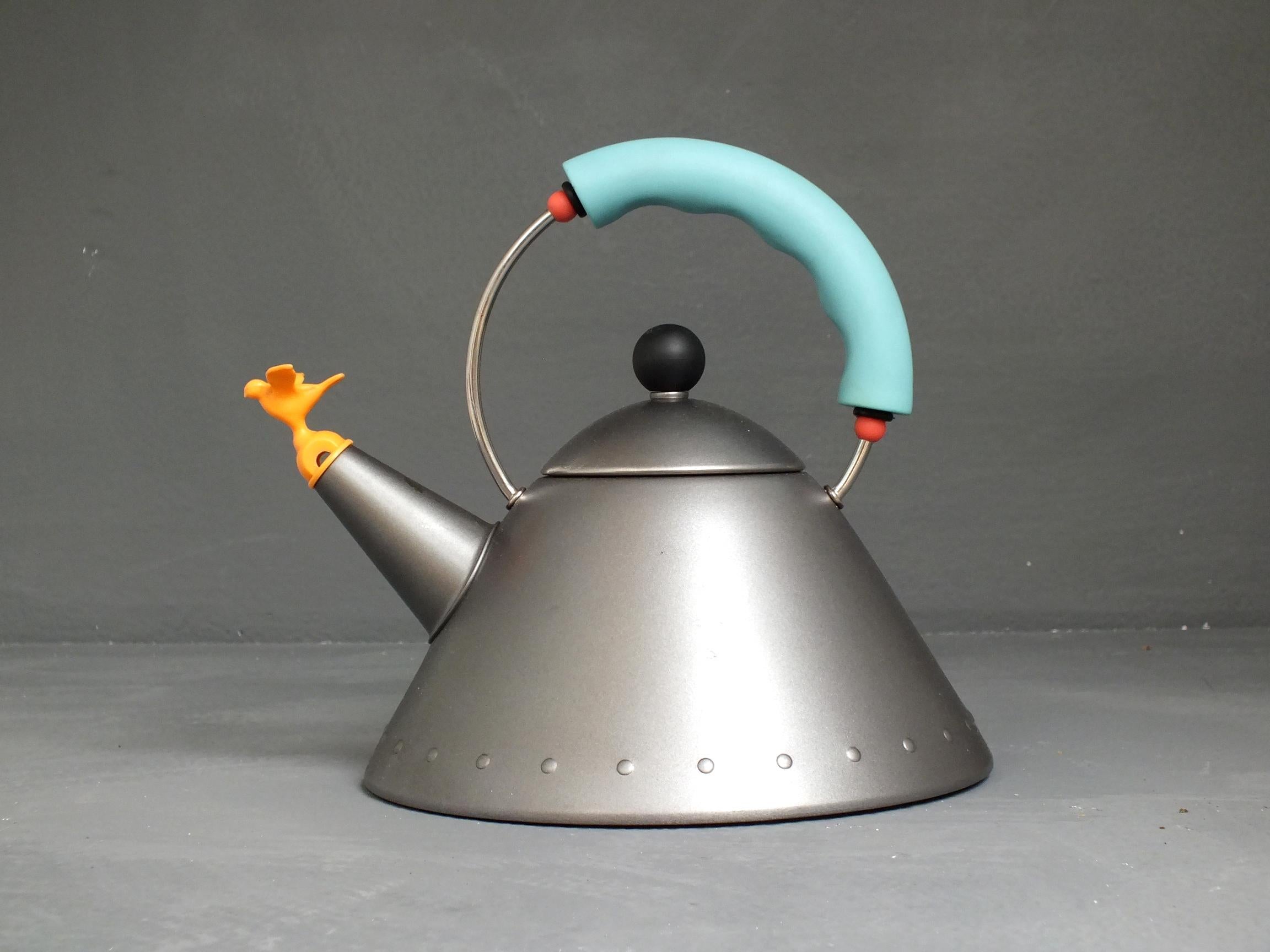 Michael Graves Postmodern tea kettle by Alessi Italy production years 1985 the first
 matte platinum grey enamel body, black knob, orange whistle bird and turquoise
 handle with red app. First edit

 good vintage condition, measure: large 11