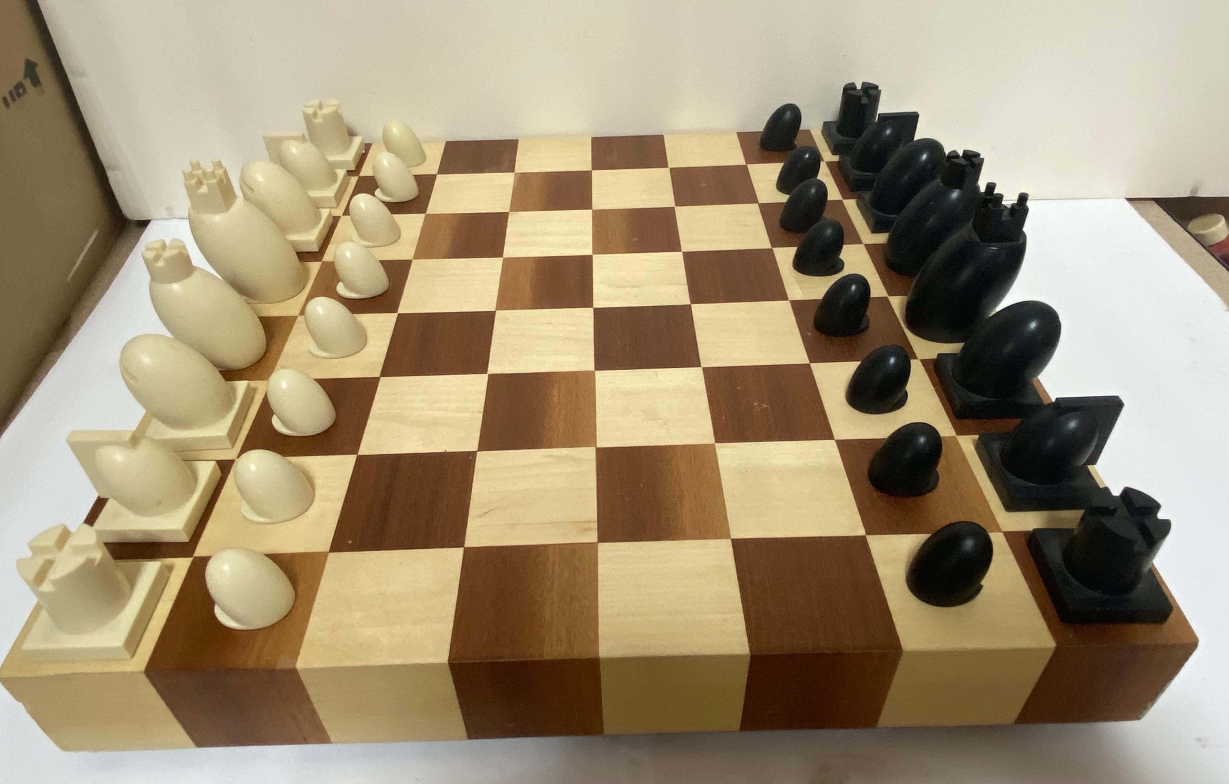 A carved wood chess and checkers set with board and box by famed architect Michael Graves. Chess board is two-toned wood and signed; each chess and pawn piece is signed Graves; USA, circa 2000.

Features resin chess and pawn pieces in faux ebony