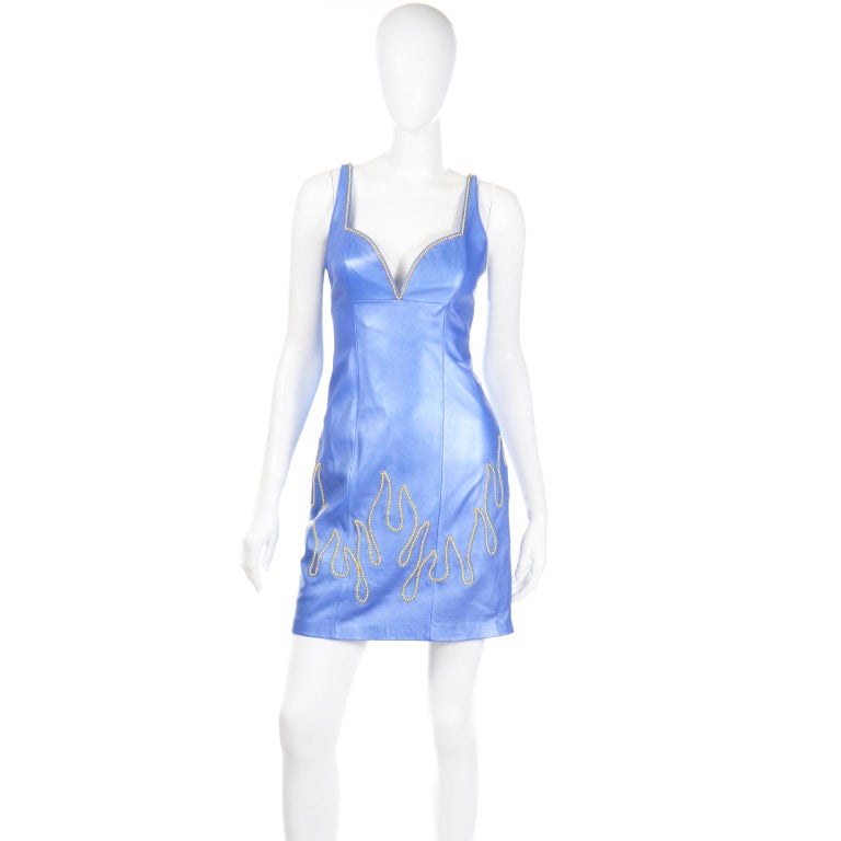 This stunning deadstock Michael Hoban for North Beach Leather pearlescent blue leather outfit includes a gorgeous bodycon dress and a zip front jacket with gold stud flame details.
We love vintage Michael Hoban leather pieces and try to buy the more