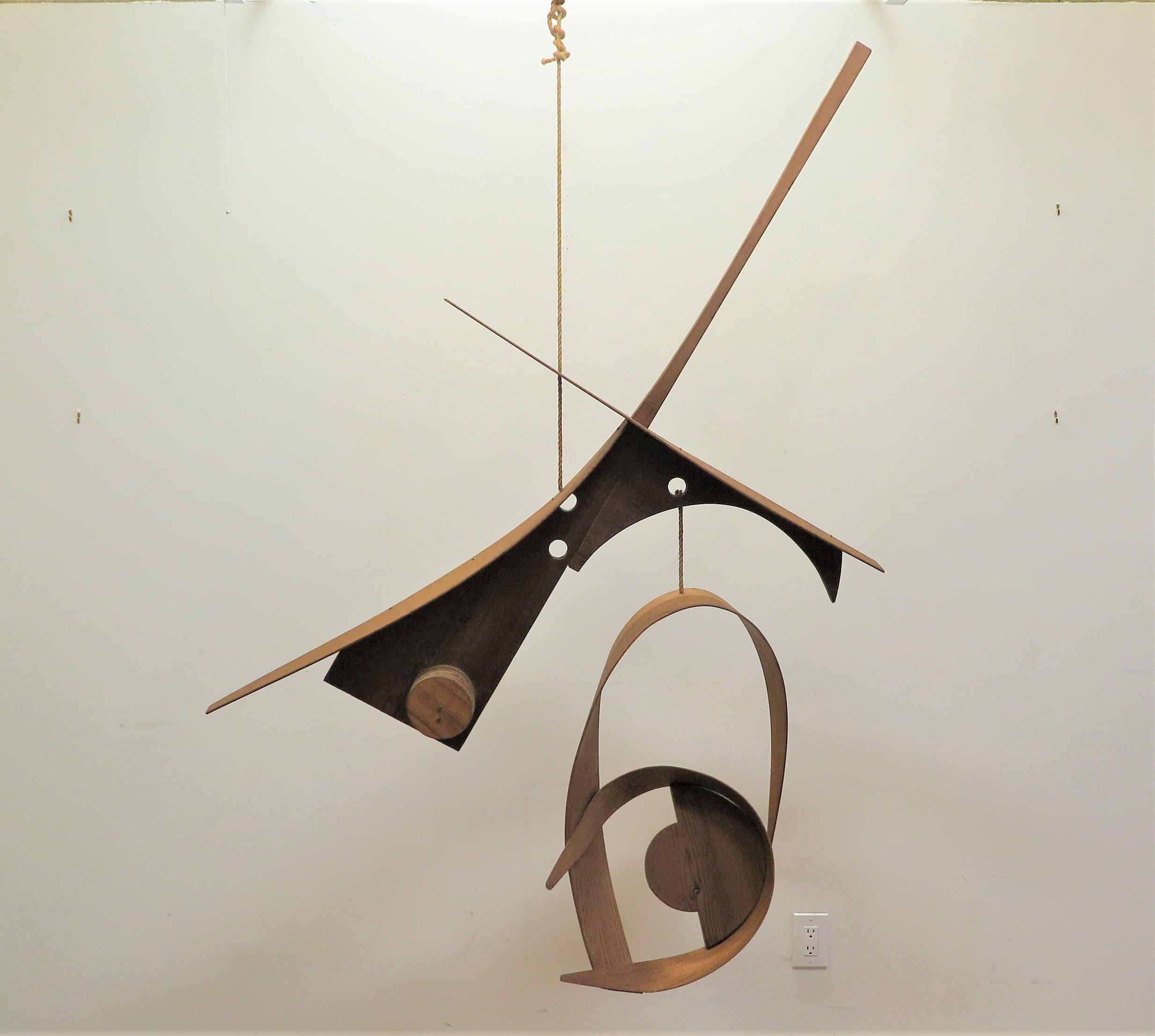 Mobil abstrait en bois de l'Artiste Michael Ince (1942- 9/2023 Américain). Sculpture d'art Mobil du milieu du siècle par Michael Ince. Une œuvre des années 1970 composée de pièces de bois assemblées et taillées, flottant comme des nuages sur une