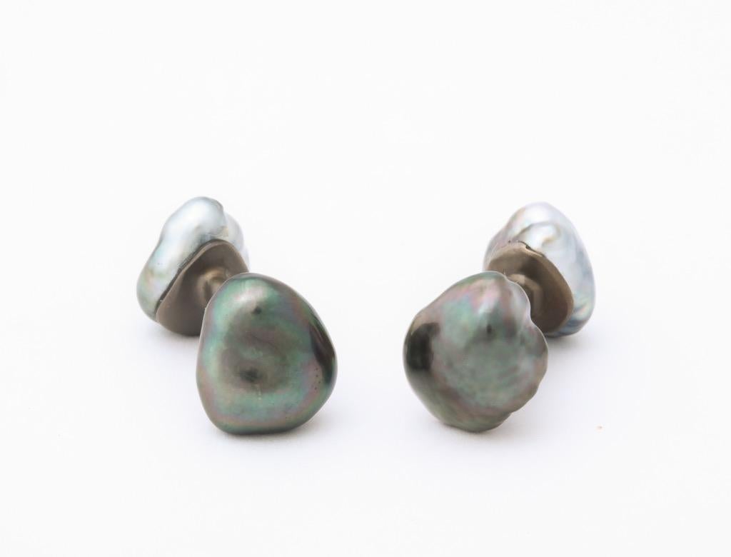 Élégants et raffinés, ces boutons de manchette en titane présentent deux superbes paires de perles keshi baroques.  La paire la plus grande (14 x 12 mm) est classée comme 