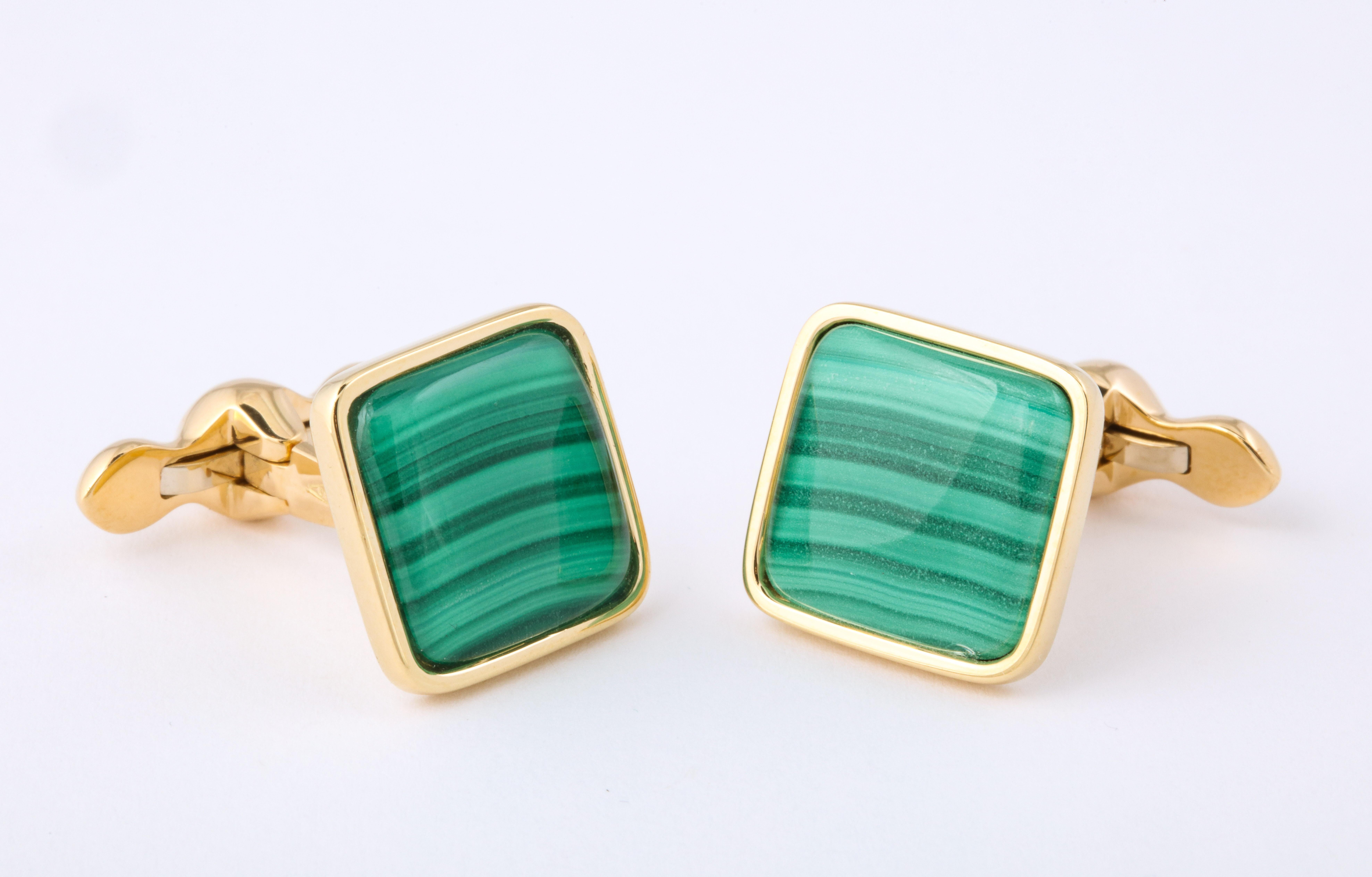 A thin slice of natural malachite is mounted under a bombé piece of rock crystal quartz.  The result is a slight magnifying effect combined with lovely volume.  The spring backs are accented with nephrite jade cabochons in a complimentary