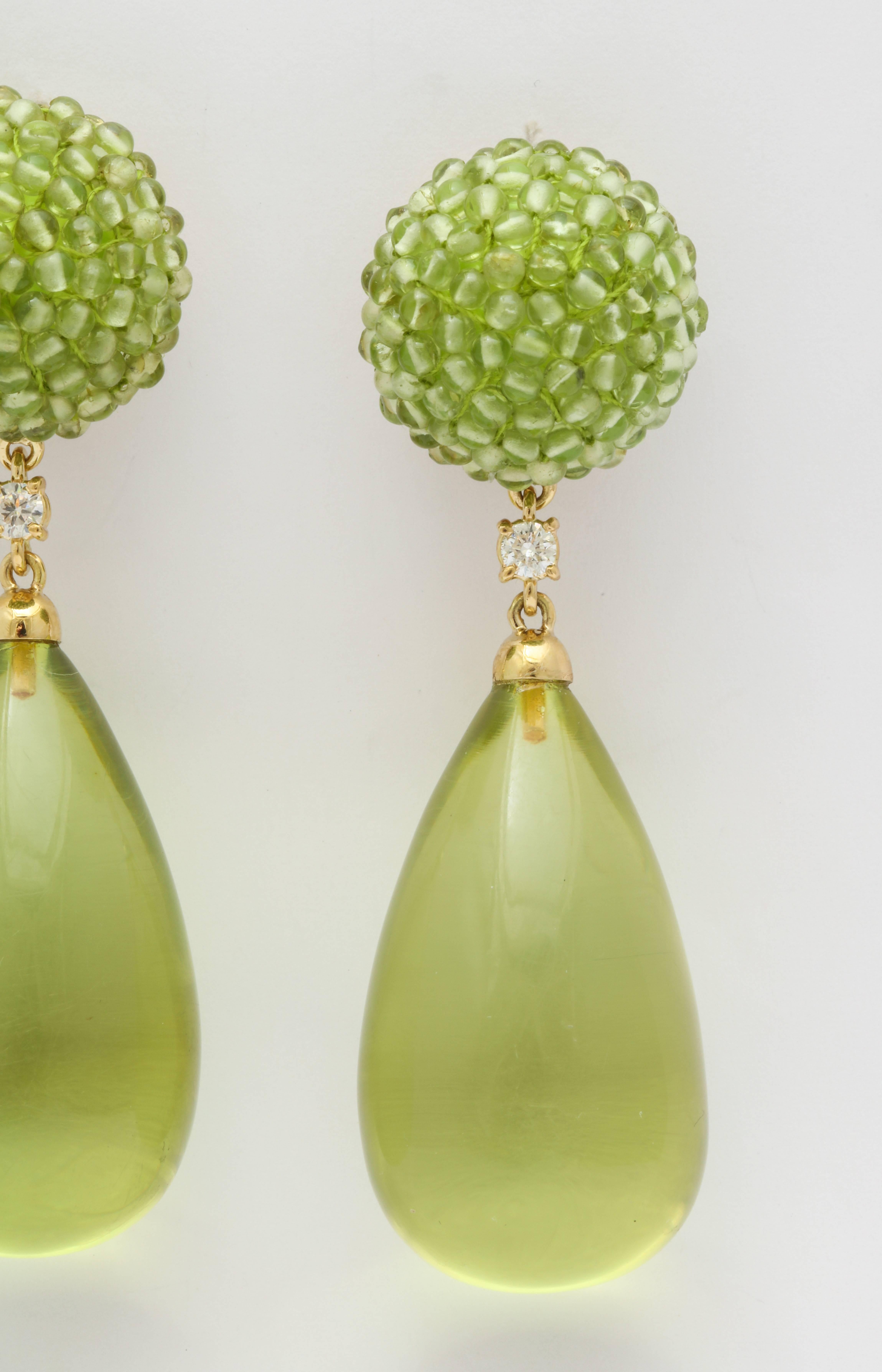 Bright, bold and fun, these fabulous earrings are guaranteed to light up your day.  The button shaped tops are made of carefully strung peridot beads and the drops are made of amber.  Connecting the two are round diamonds and the mounting is 18kt