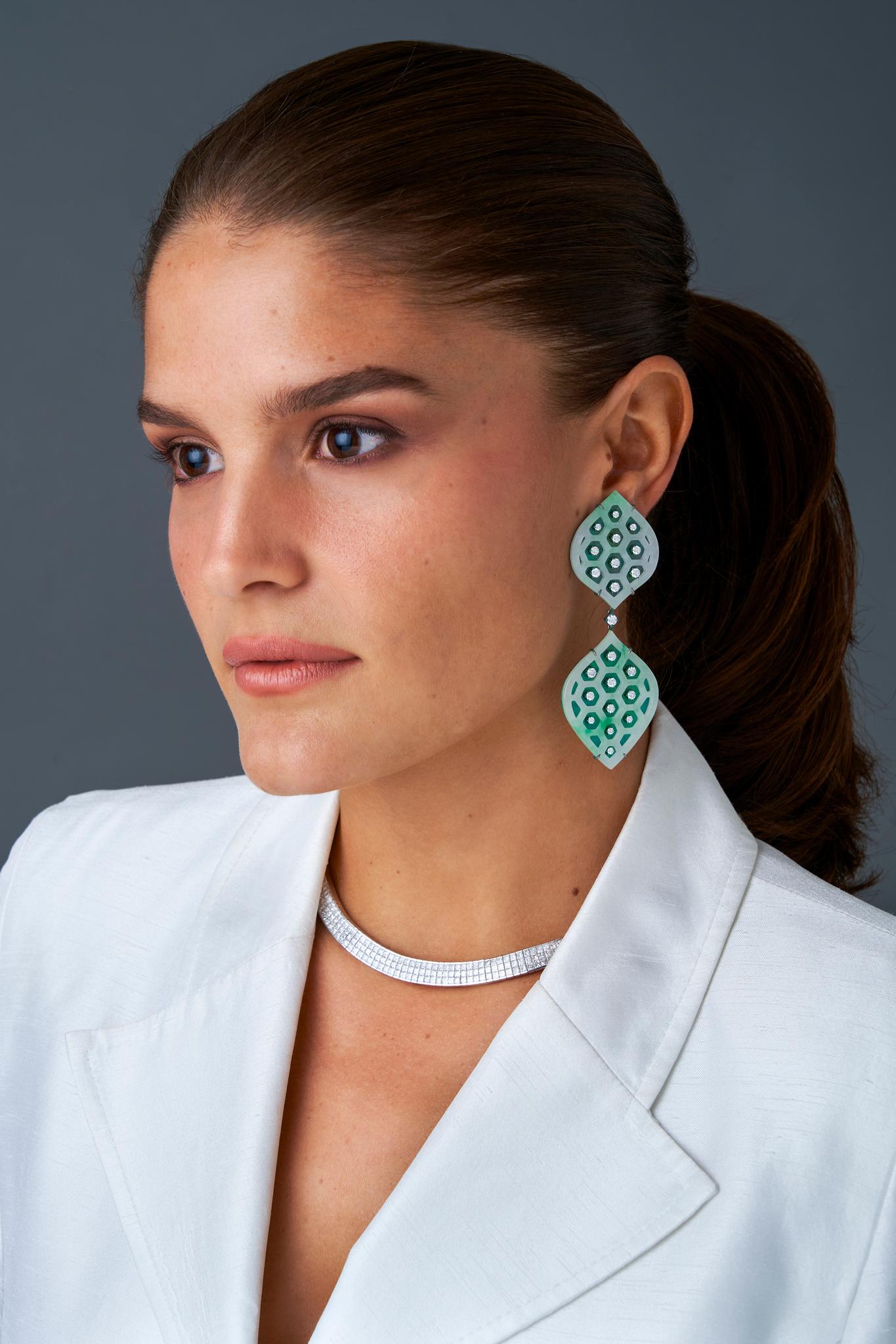 Introducing an exquisite pair of carved jade and diamond earrings, mounted in anodized green titanium.  These stunning earrings feature a combination of rare and luxurious materials, making them a true statement piece that will elevate any outfit. 