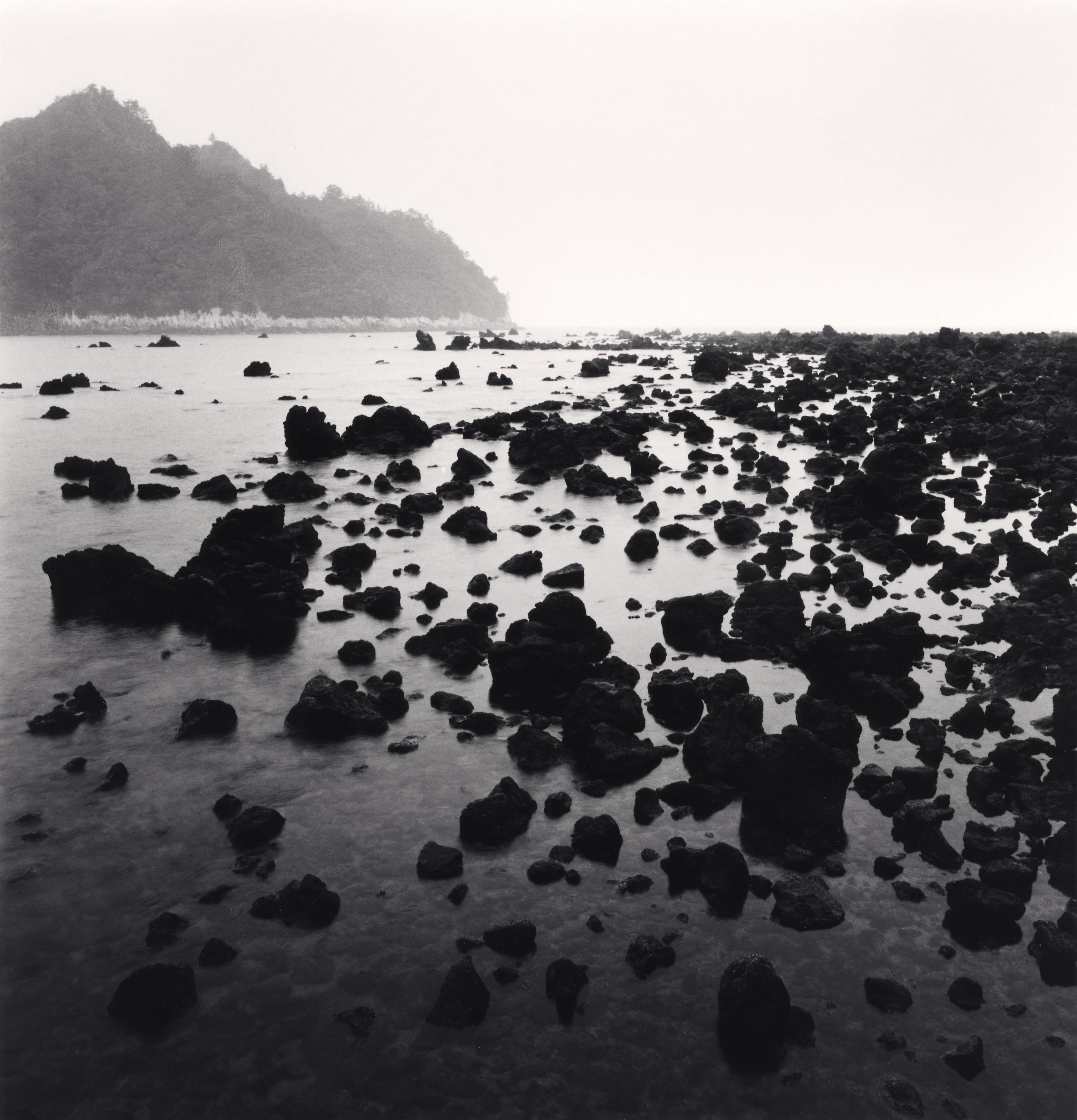 Michael Kenna Landscape Photograph - Black Beach Rocks, Supseom, Jeju Island, South Korea