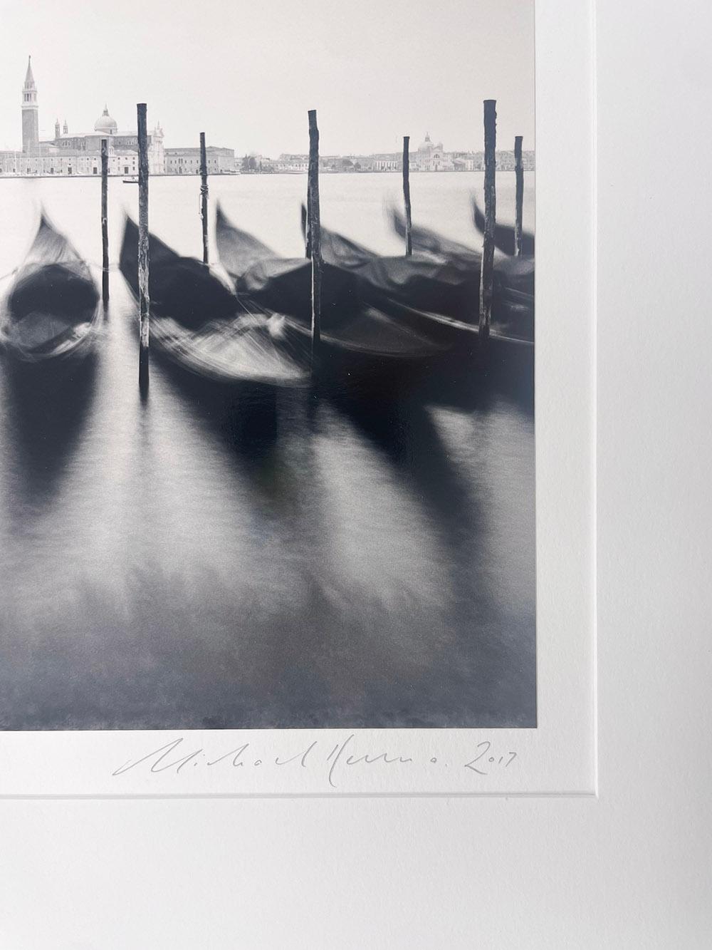December Gondolas, Venice, Italy by Michael Kenna is a black and white photograph depicting a row of boats floating in the river, blurry from the intense waves.

Gelatin Silver Print
Mat size: 20 x 16 in.
Image size: 8 x 7.75 in.
Ed. 10/25
Signed,