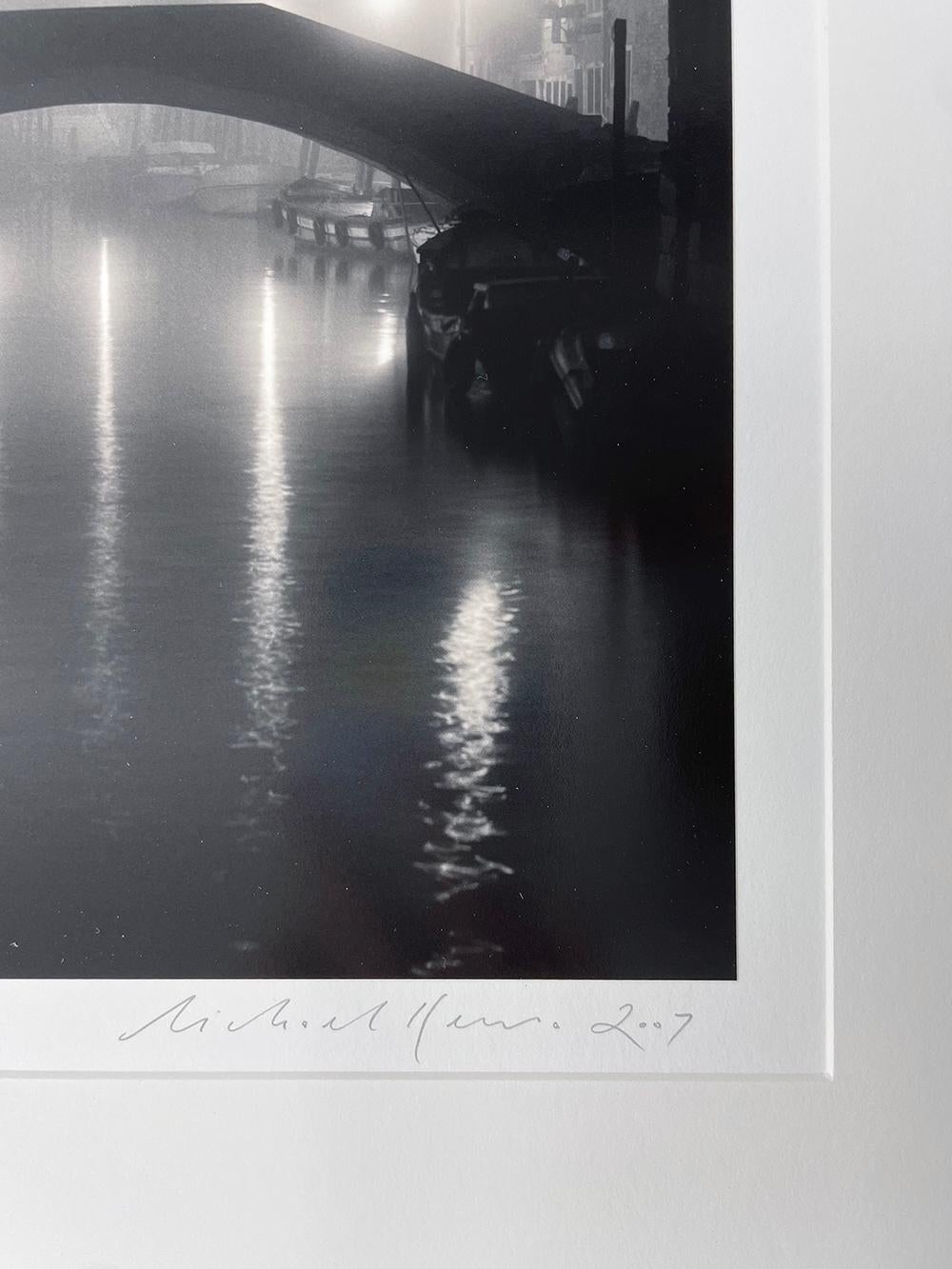 Ponte Fondamenta Bonini, Venice, Italy by Michael Kenna is a black and white photograph depicting a night time scene of an empty bridge over a calm river.

Gelatin Silver Print
Mat size: 20 x 16 in.
Image size: 8 x 7.5 in.
Ed. 10/45
Signed, dated