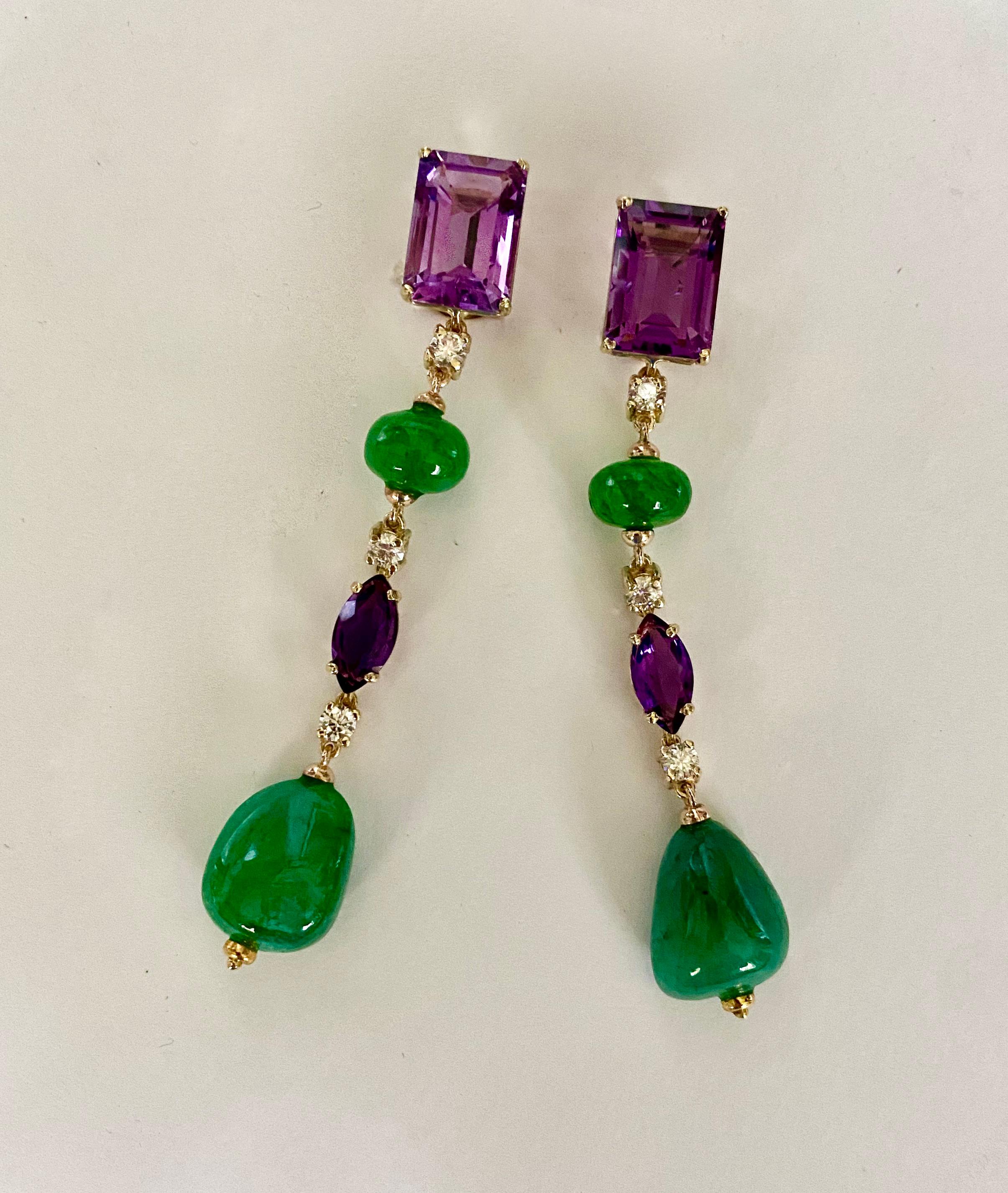 L'améthyste est associée à l'émeraude dans ces boucles d'oreilles pendantes spectaculaires.  Les améthystes (origine : Brésil) sont taillées en émeraude et en marquise.  Elles sont d'un violet vif et très bien coupées.  Les émeraudes (origine :