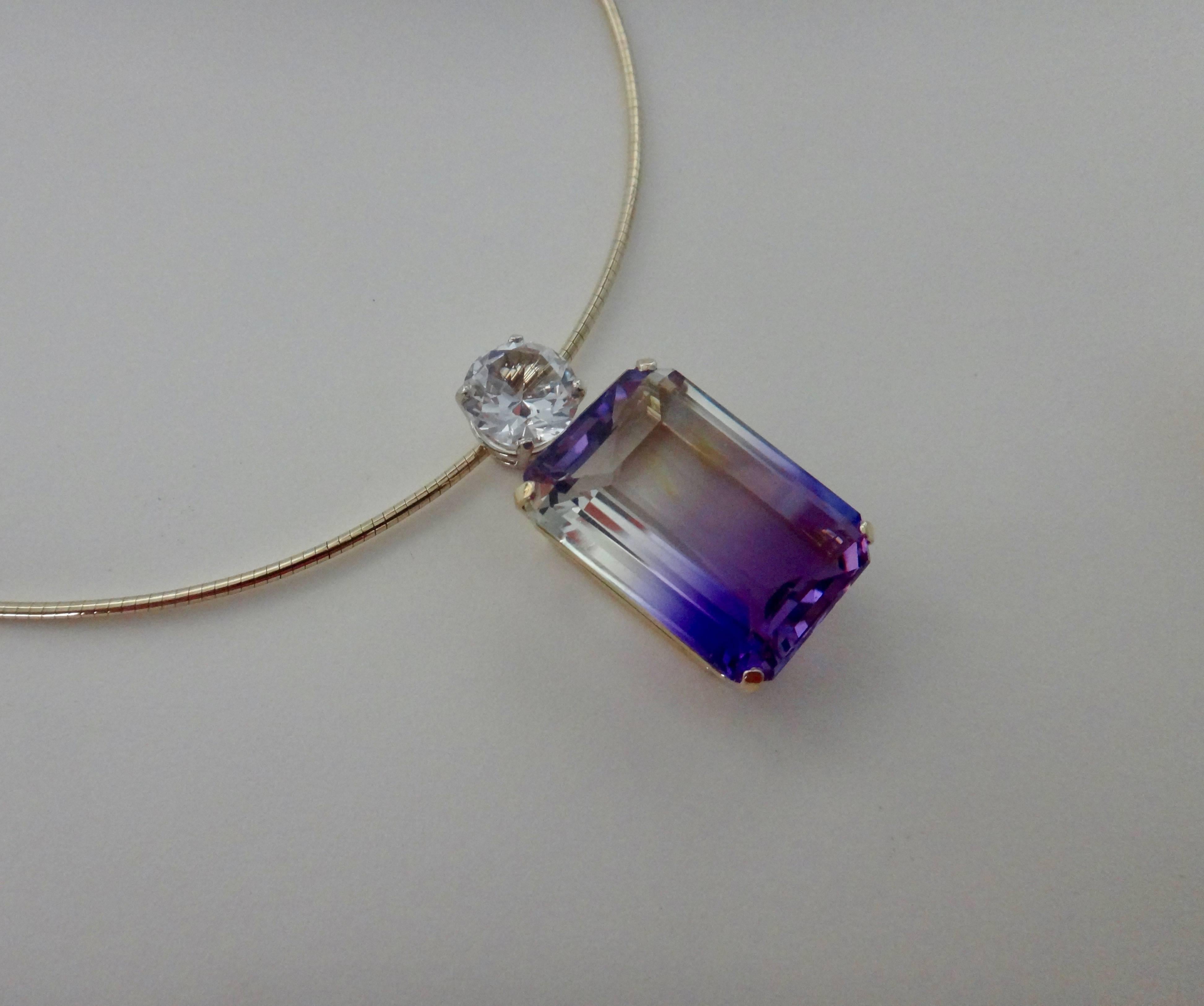 An emerald cut ametrine (origin: Bolivia) of 35 carats is the featured attraction in this one-of-a-kind pendant.  The gem is unusual in that it's purple and clear rather than the more common purple and gold.  The ametrine is well cut, polished and