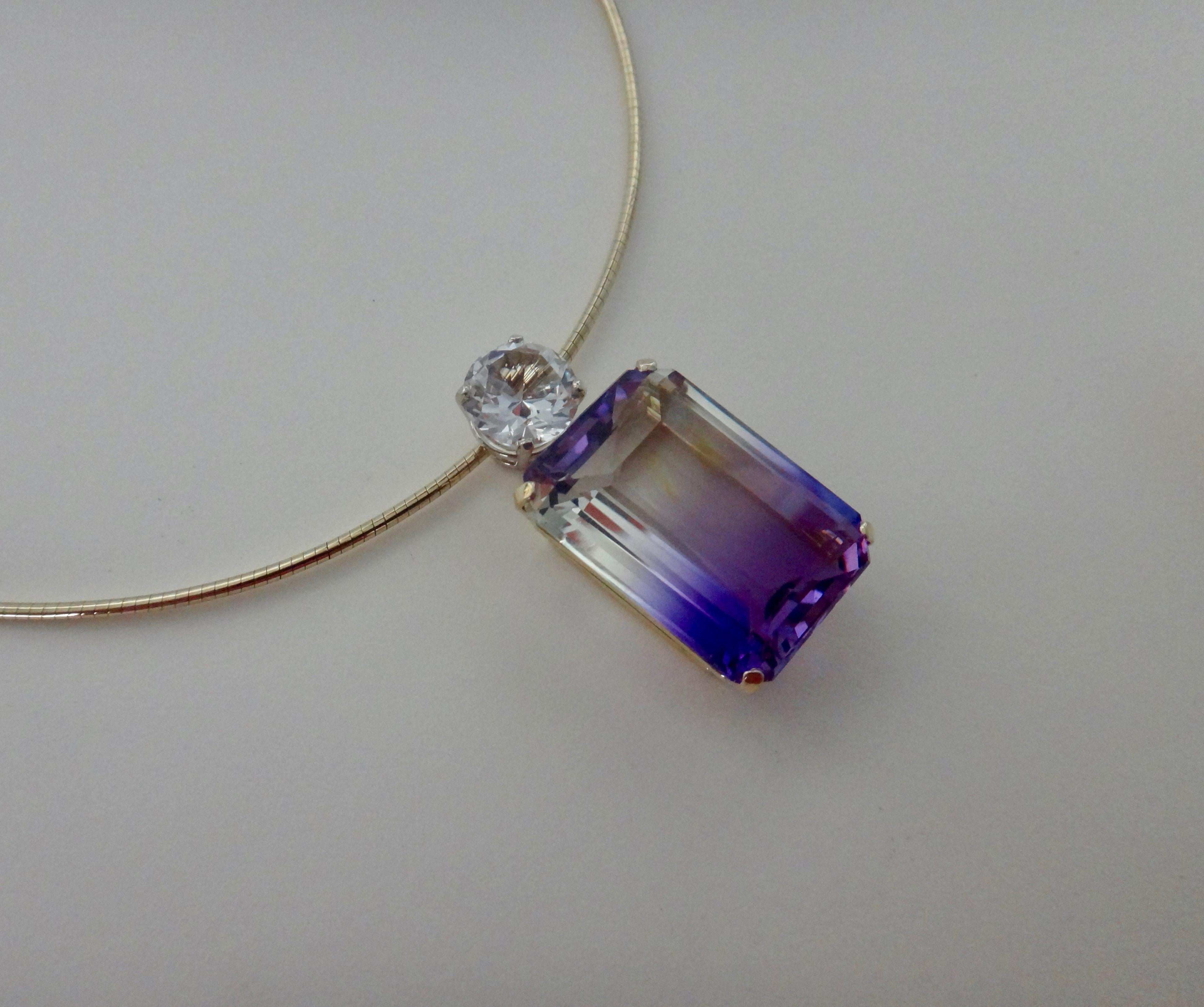An emerald cut ametrine (origin: Bolivia) of 35 carats is the featured attraction in this one-of-a-kind pendant.  The gem is unusual in that it's purple and clear rather than the more common purple and gold.  The ametrine is well cut, well polished
