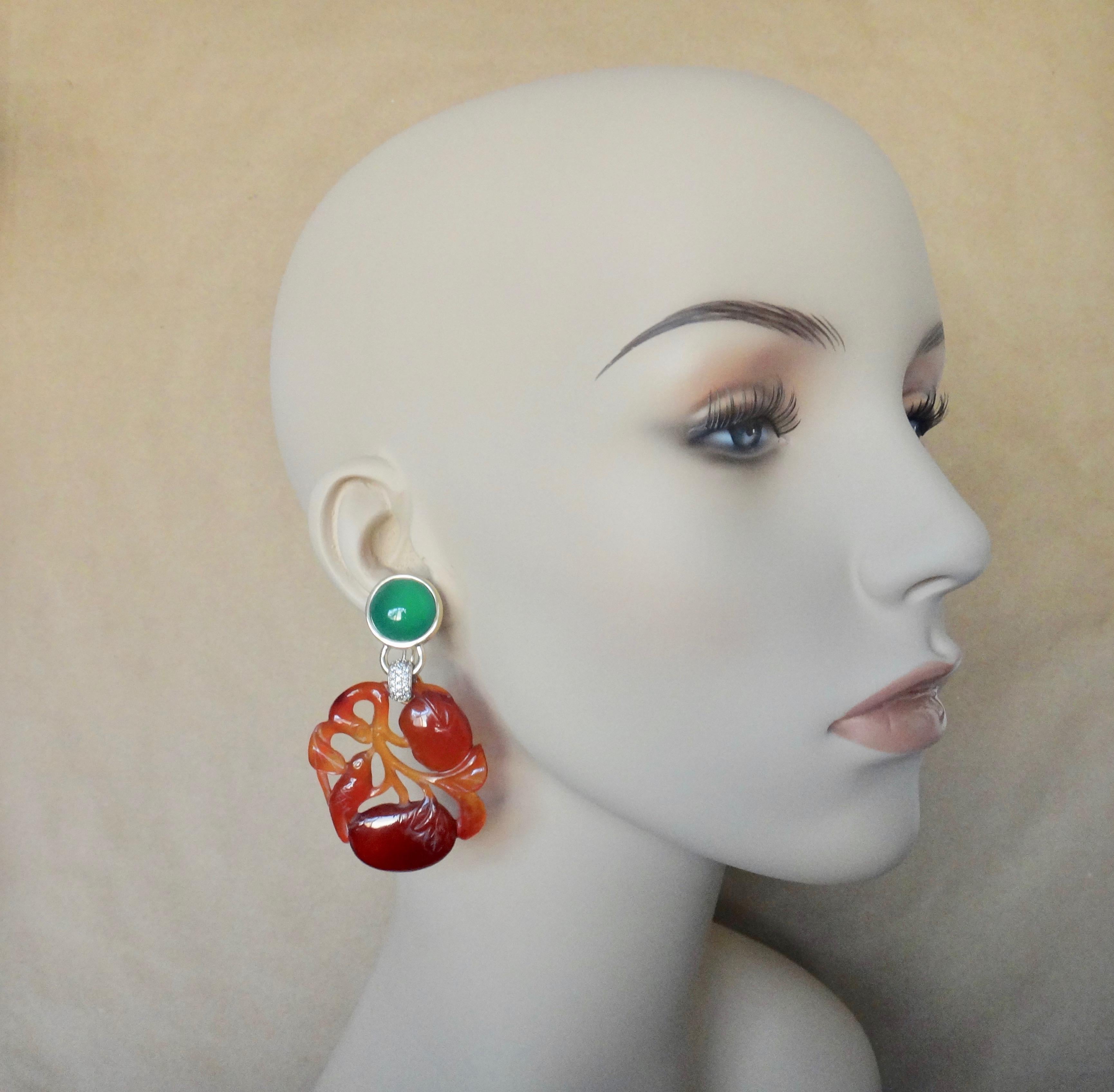 Antique Chinese plaques of carved carnelian in the form of persimmons with vines, birds and leaves are the center of attention in these dramatic dangle earrings.  The carving's exquisite craftsmanship and bold orange color is complimented by a pair
