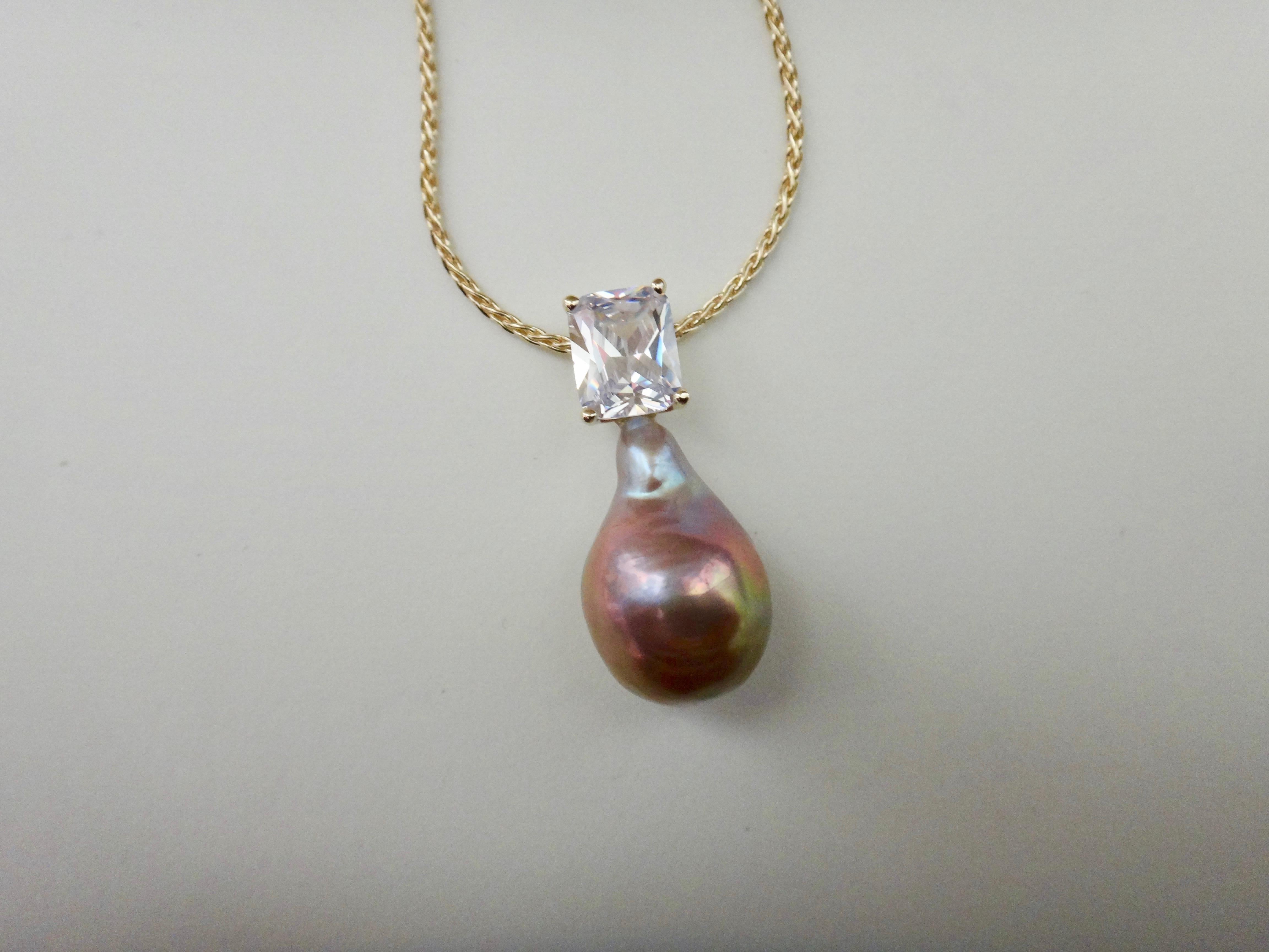 A luminous baroque pink Kasumi pearl (origin: Japan) is paired with a radiant cut white sapphire in this classic and wearable pendant.  Kasumi pearls are well known for their rich colors and metallic finish.  This pearl measures 7/8 inch long and