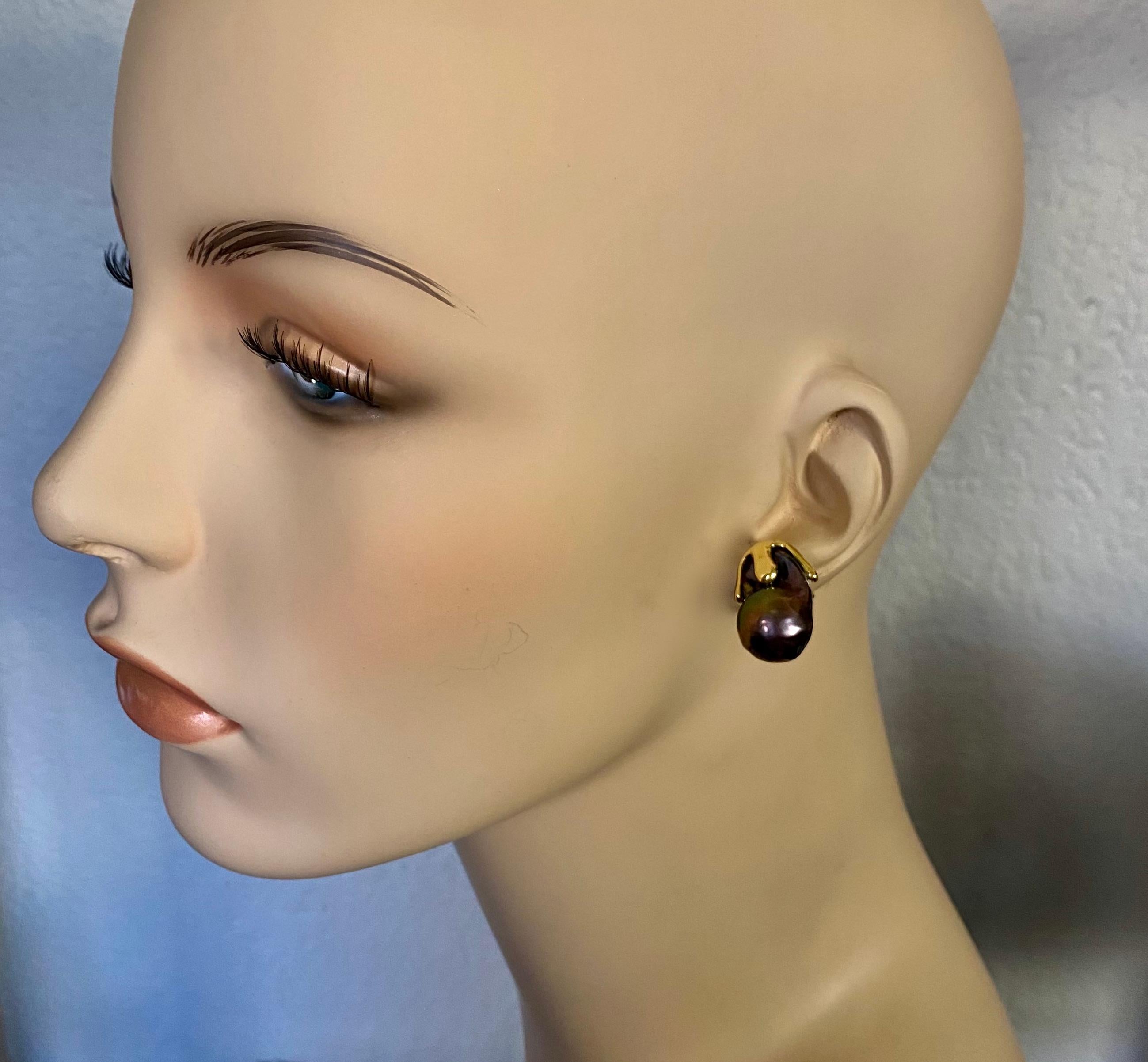 Barocke Süßwasserperlen zieren diese auffälligen Aqueous-Ohrringe.  Die gut aufeinander abgestimmten auberginefarbenen Perlen besitzen einen brillanten Glanz und reflektieren eine Reihe anderer Pfauenfarben.  Die Perlen sind in handgefertigte