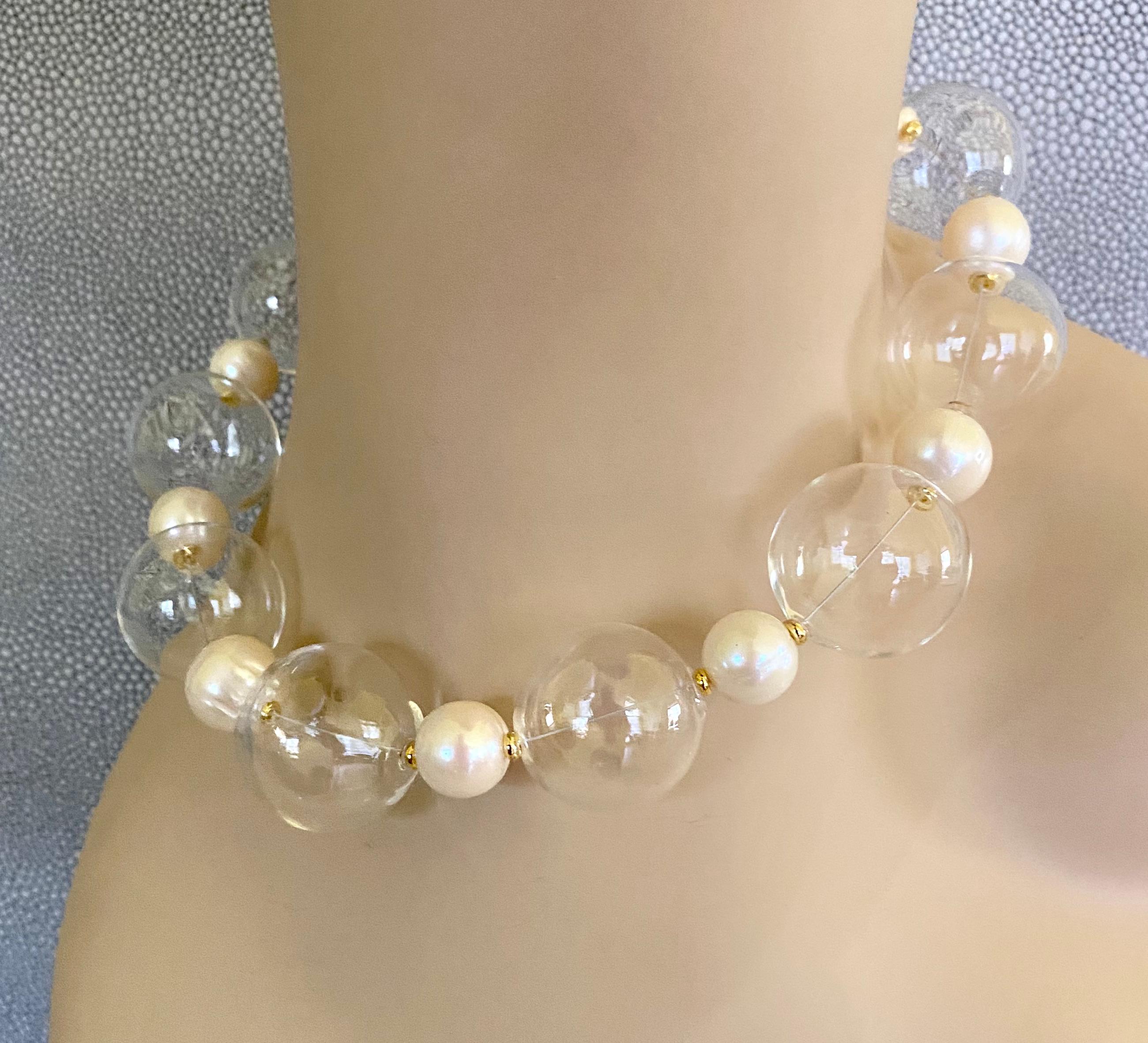 Die mundgeblasenen Glasblasen werden bei dieser sprudelnden Halskette mit weißen Barockperlen kombiniert.  Die Perlen messen großzügig 1 Zoll und sind makellos gestaltet.  Sie sind mit 12 mm großen weißen Barockperlen und goldenen Rondellen besetzt.