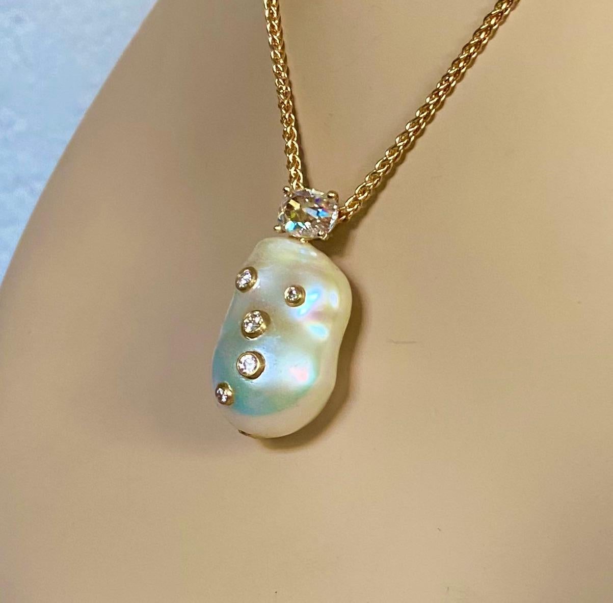 A ginormous white freshwater pearl is featured in this elegant pendant.  The pure white pearl (origin: China) is baroque in shape and possesses a high luster and a blemish-free surface.  It has been studded with six bezel set diamonds of various