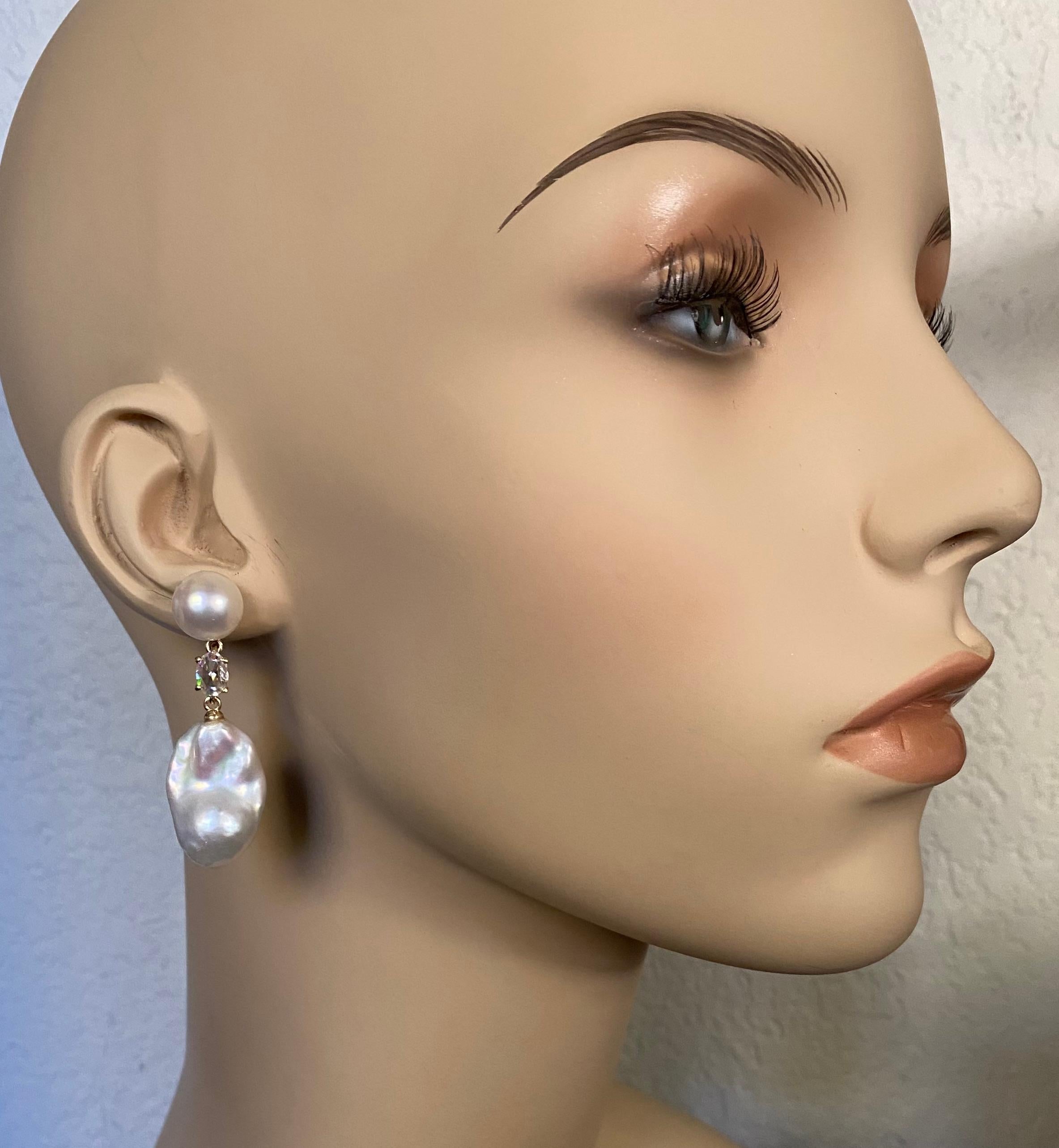 Baroque pearls are featured in these elegant dangle earrings.  The white pearls (origin: China) possess brilliant luster, are blemish free and are in shapes typical of baroque pearls.  They are complimented by white button pearls that are similar in