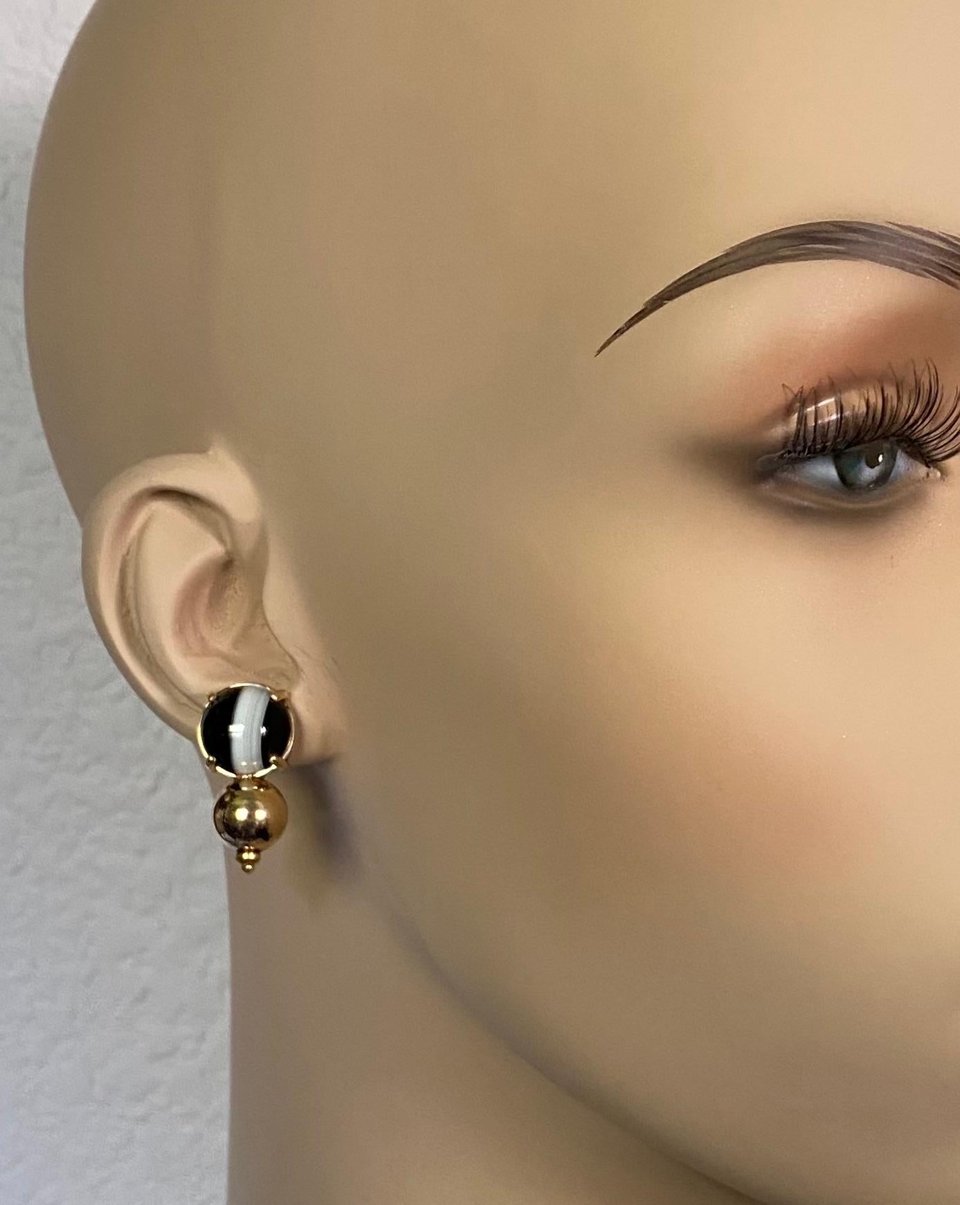 Black and white banded agate is featured in these striking drop earrings.  The cabochon cut agates (origin: Brazil) are perfectly matched, cut and polished.  The hand fabricated gold mountings have large spheres mounted below which highlight the