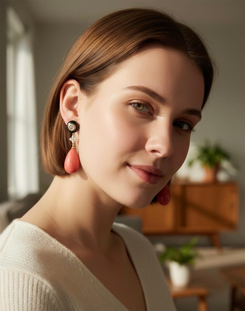 Gocce di conchiglia rosa sono presenti in questi orecchini pendenti audaci e drammatici.  Le perle a bottone sono incastonate con zaffiri rosa pallido, che richiamano il rosa delle gocce di conchiglia.  Il  Le perle sono di un nero intenso e