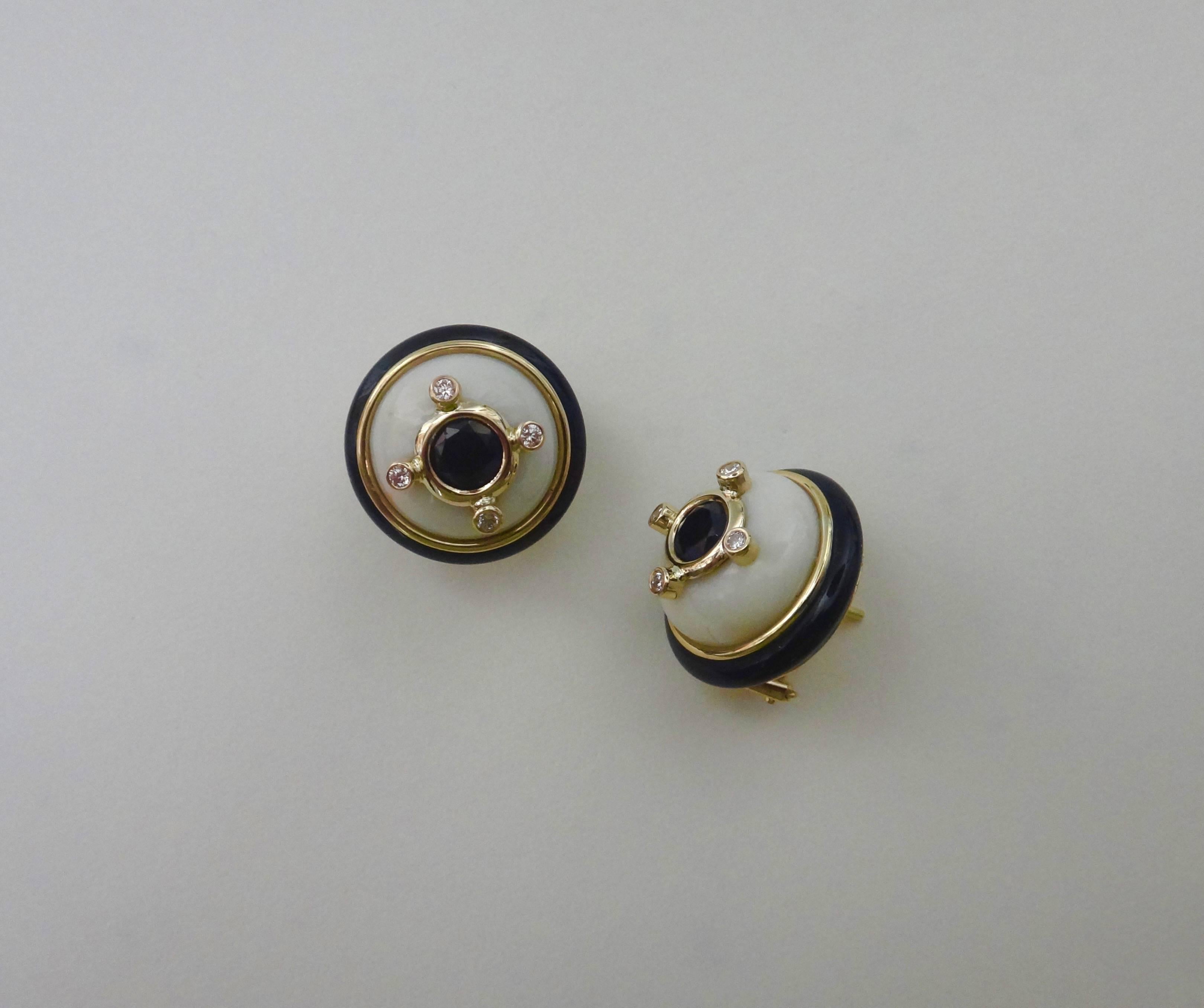 Classic and stately, these button earrings are composed of bezel set black spinels and white diamonds mounted on white coral domes and framed with black onyx.  All the gems are mounted in 18k yellow gold.  The earrings come with posts and omega clip