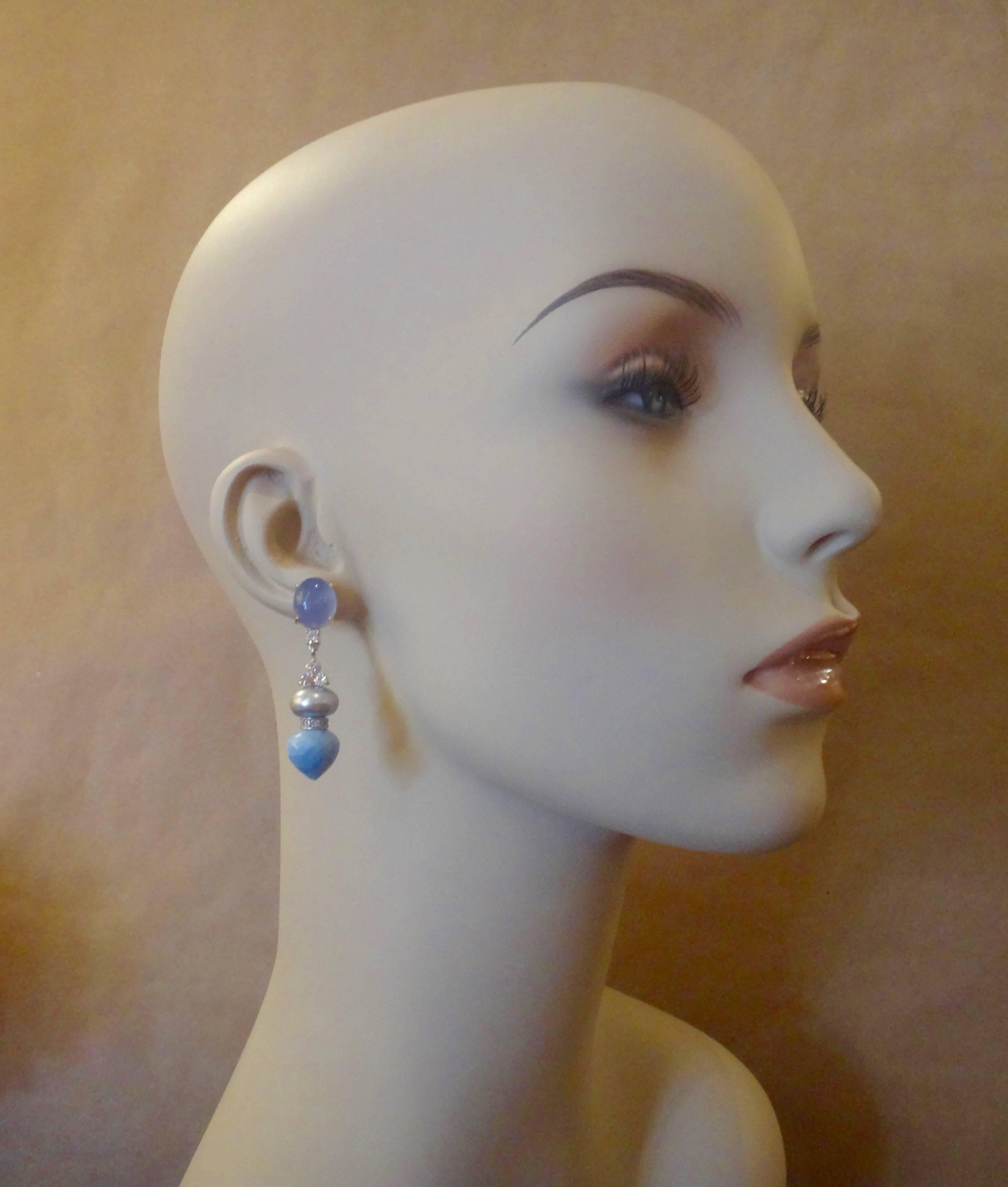 Cabochon blue chalcedony, white diamonds, gray pearls and Peruvian blue opals combine to create these dangle earrings.  The chalcedony is a cooling blue color which compliment the frosty blue/gray of the opals.  The opals themselves are shaped in a