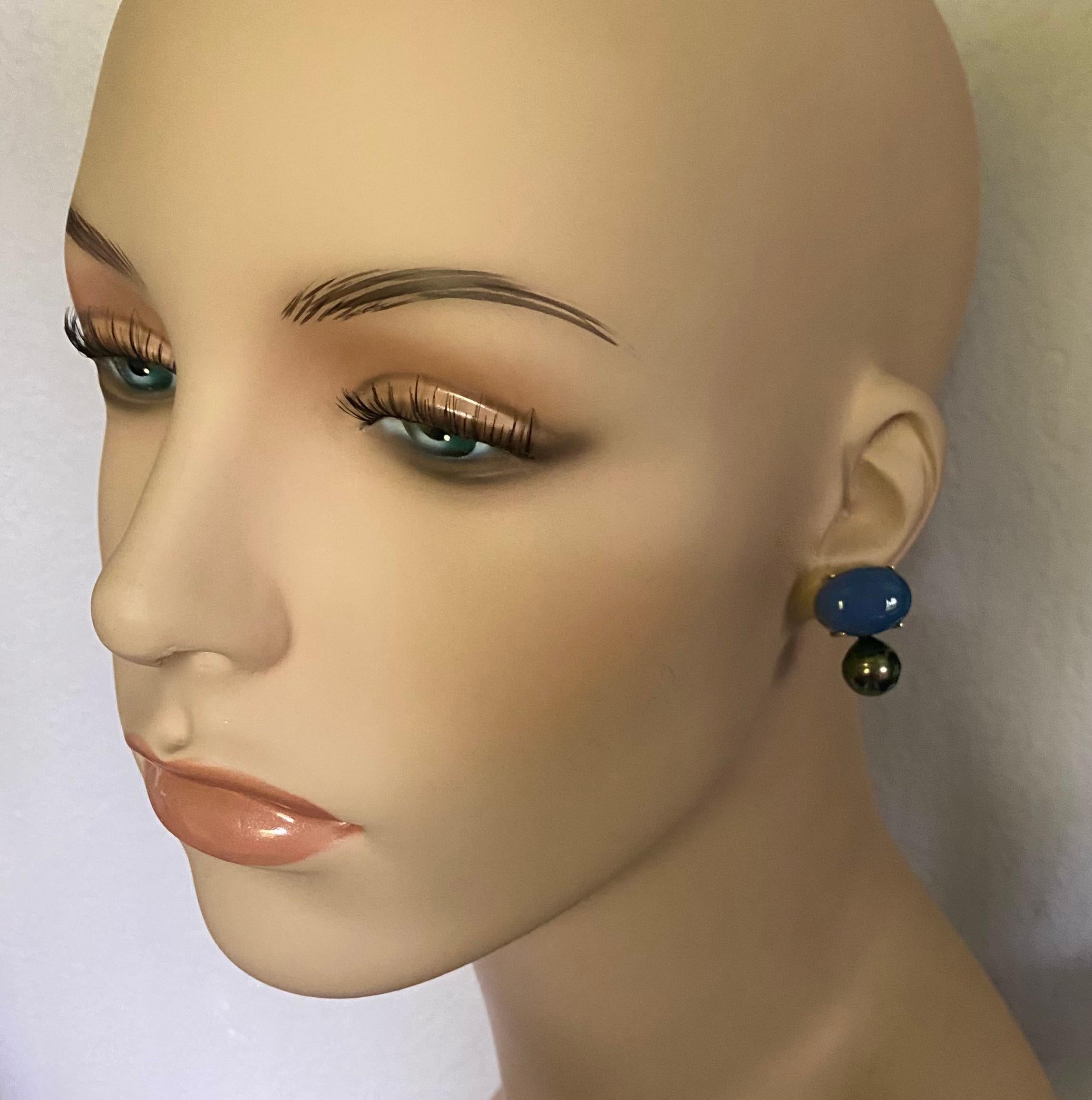 Blue chalcedony cabochons are paired with Tahitian pearls is these simply elegant drop earrings.  Blue chalcedony has been continually mined in Turkey since Roman times.  Also known a Blue Turk Chalcedony, the gem remains highly regarded.  This pair